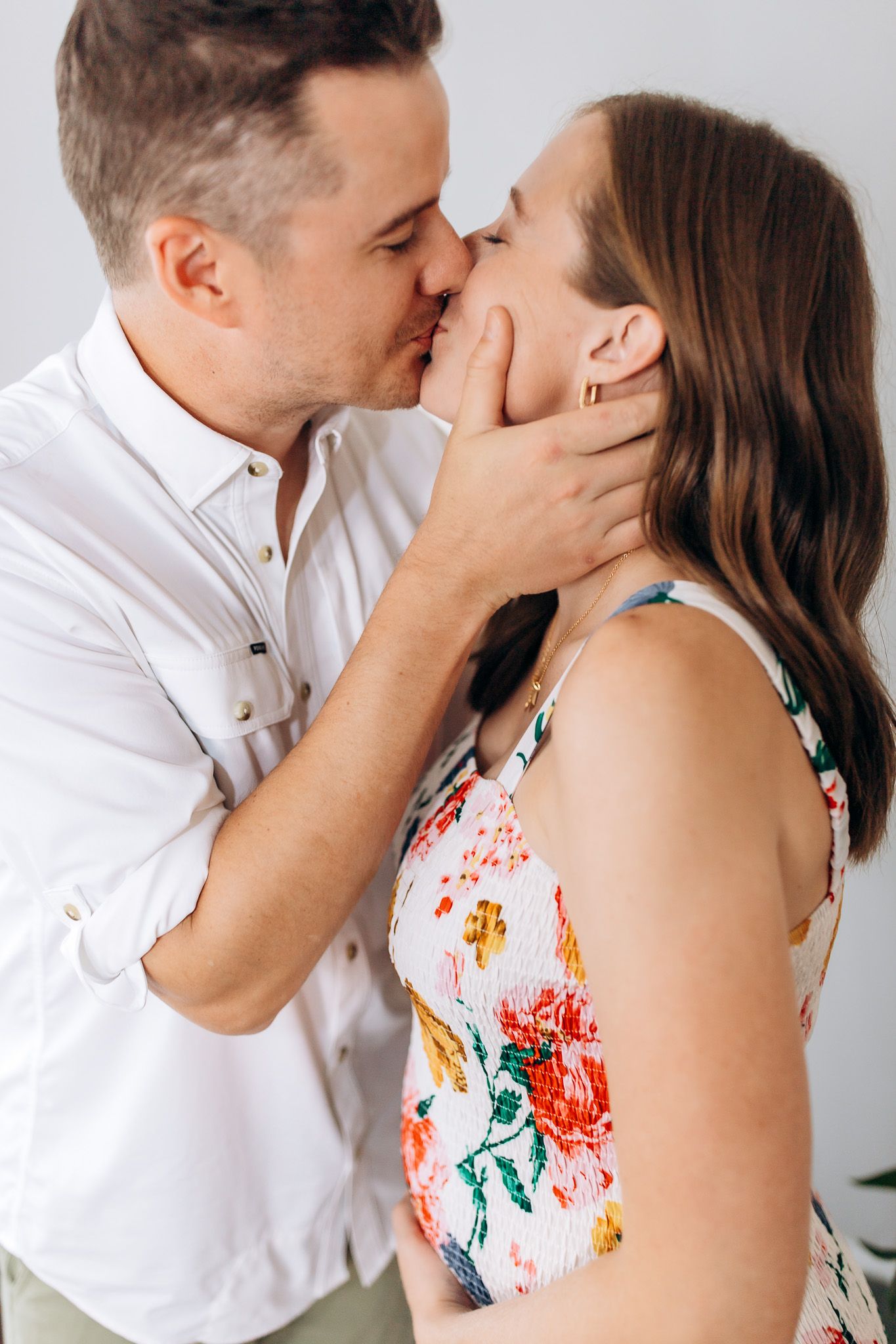 A loving couple sharing a kiss in the studio during their family session, photographed by Jessica Rose Photography in Janesville, Wisconsin.
