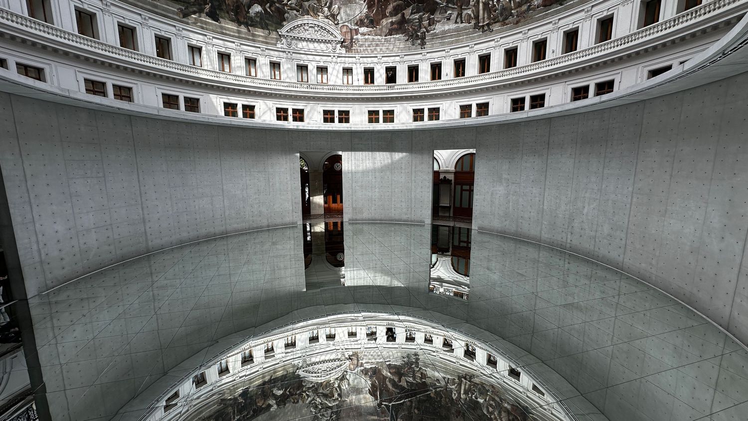 Modern circular architectural space with concrete walls and dual doorways.