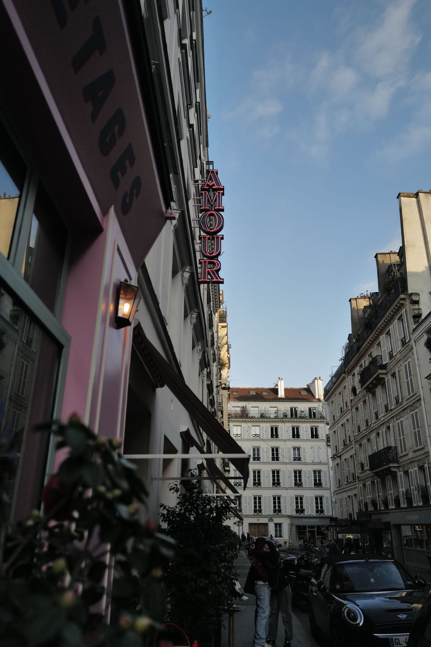 Narrow Parisian street view with classic architecture and moody lighting between buildings.