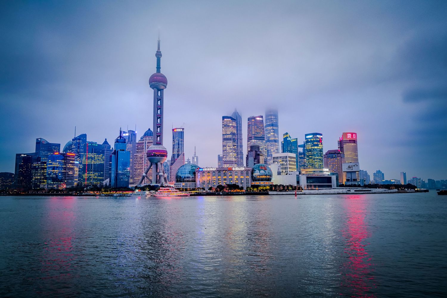 Blue hour view of Shanghai's futuristic Pudong skyline with Oriental Pearl Tower.