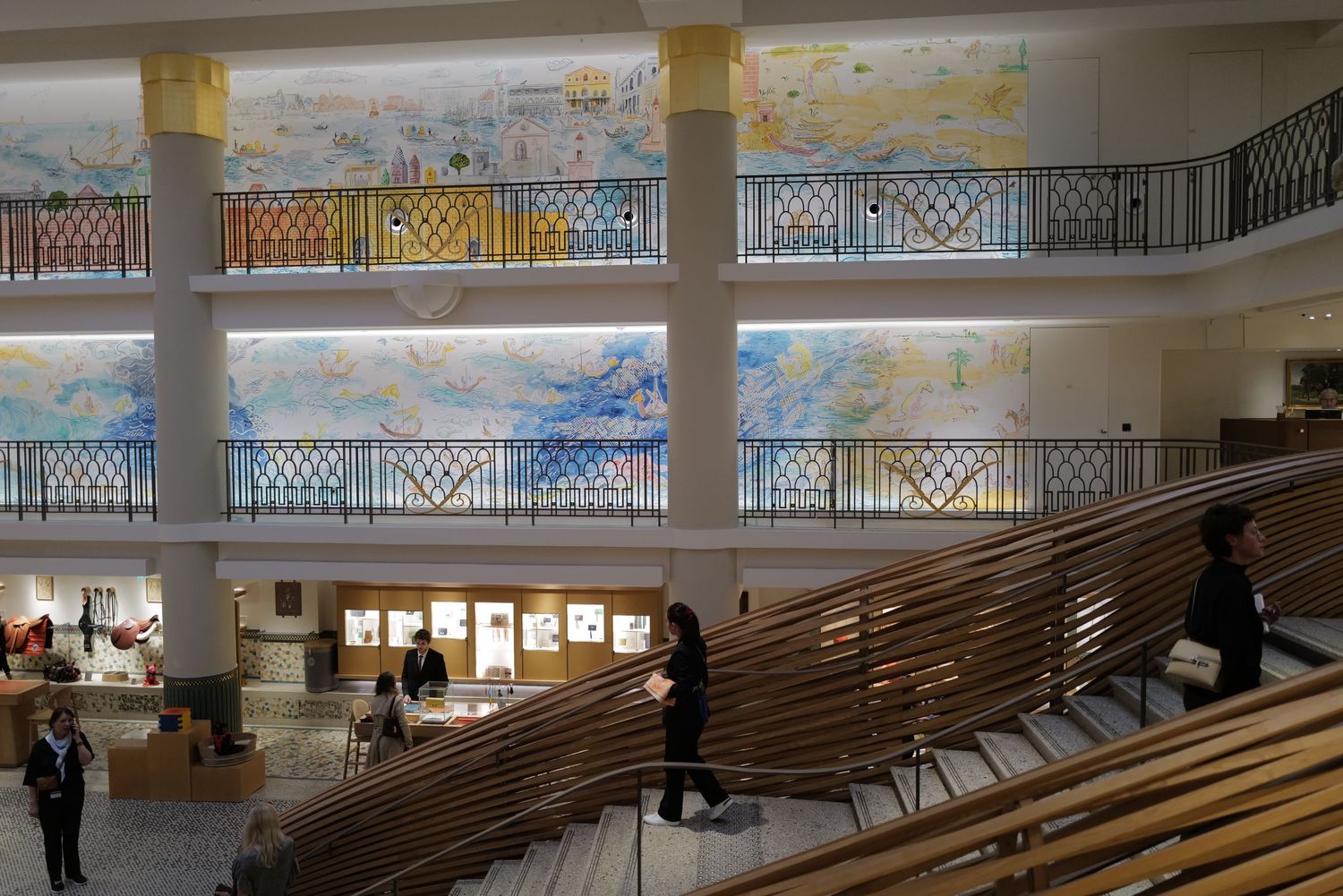 Modern shopping mall interior featuring curved wooden architectural installation and multiple levels.