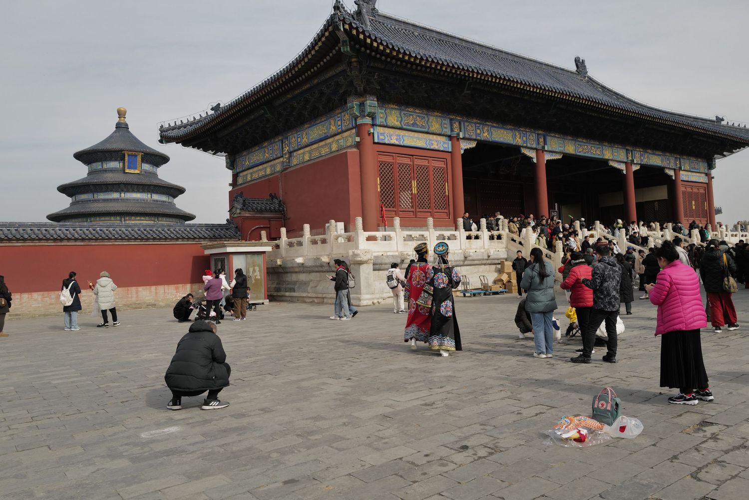 Temple of Heaven complex in Beijing with traditional architecture and visitors in the courtyard.