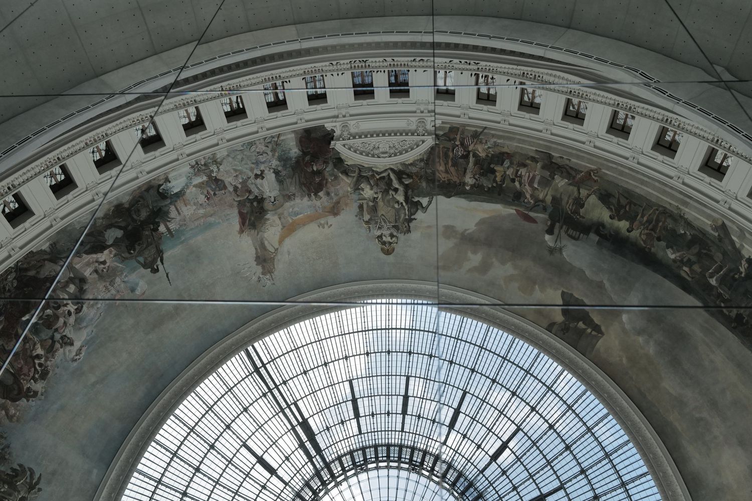 Ornate glass domed ceiling with intricate architectural details and natural light streaming through.