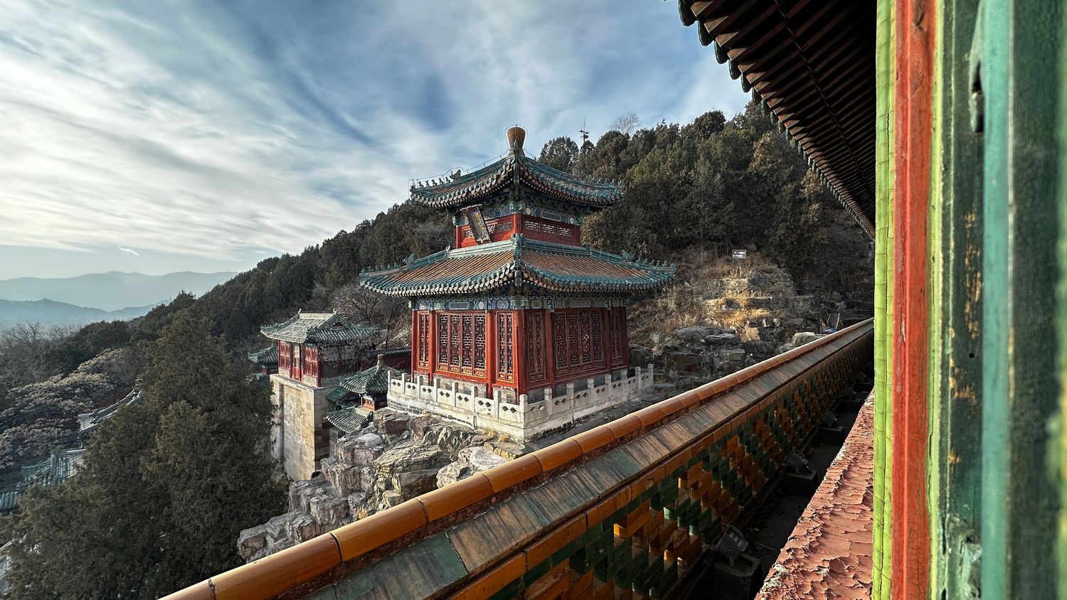 Panoramic mountain landscape with traditional Asian architecture and buildings nestled on hillside.