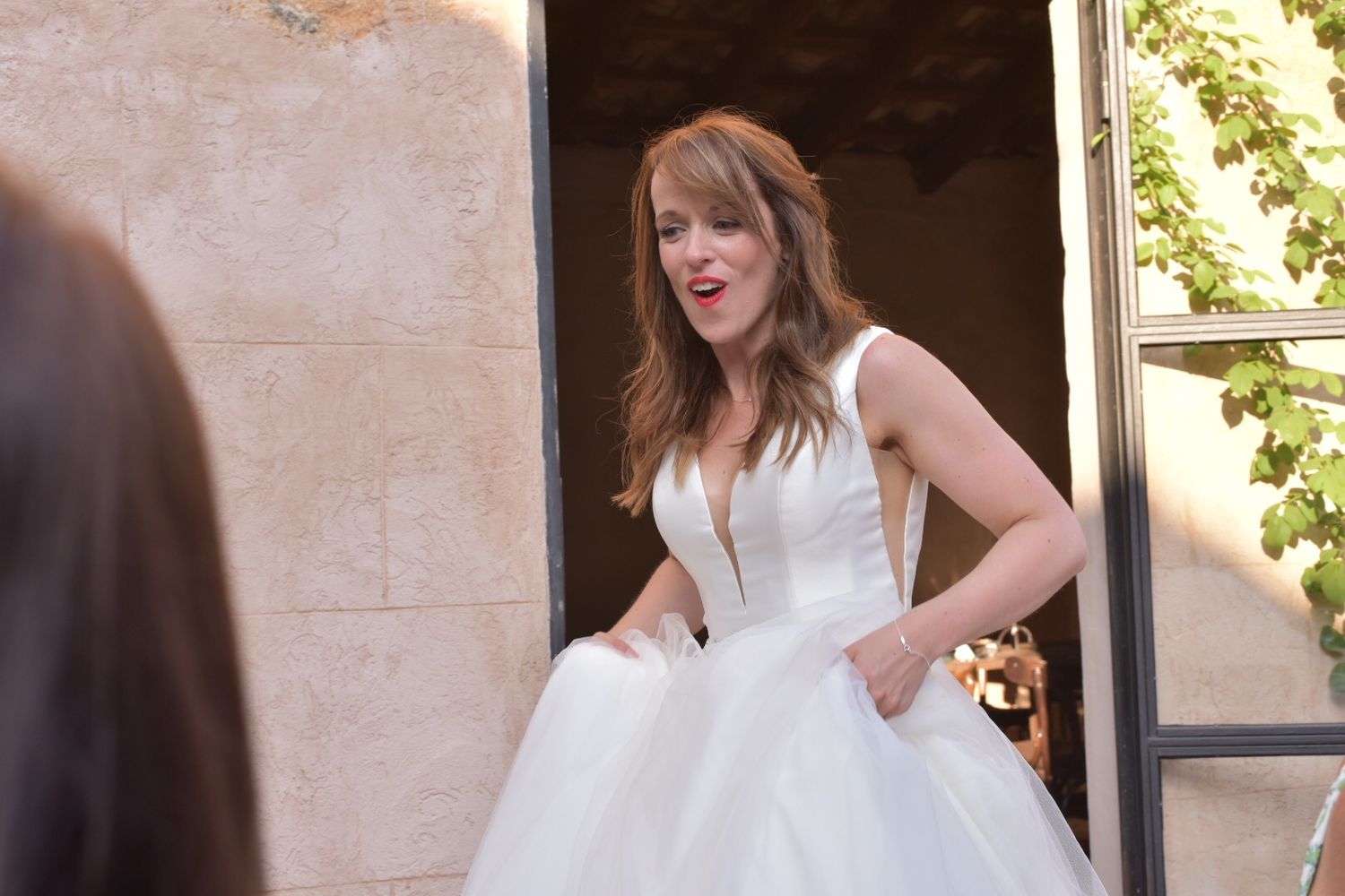 Sunlit wedding celebration moments captured in front of a stone building entrance.