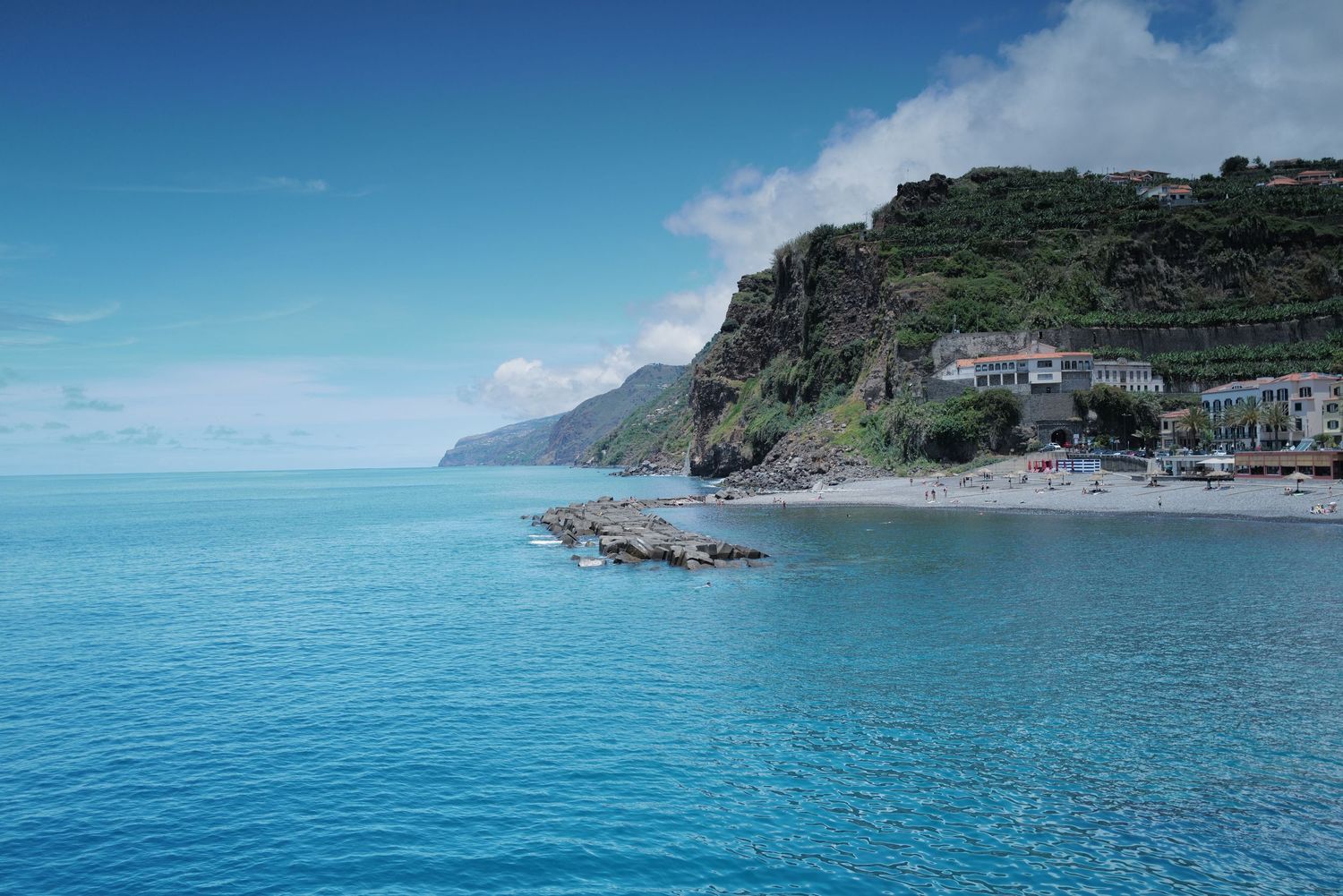 Turquoise Mediterranean coastline with rocky cliffs and clear blue waters.