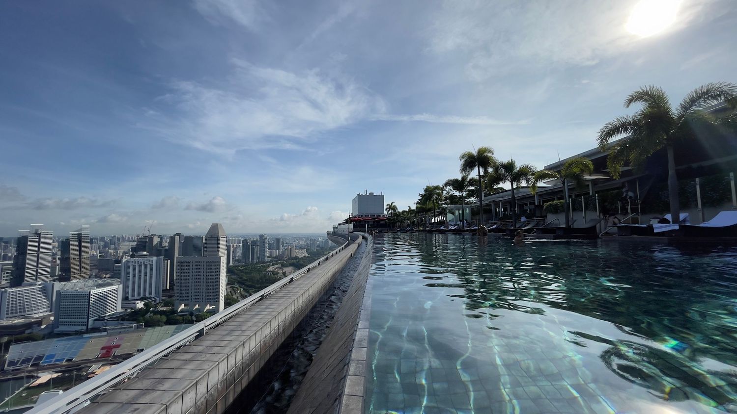 Marina Bay Sands infinity pool overlooking Singapore's urban skyline on a sunny day.