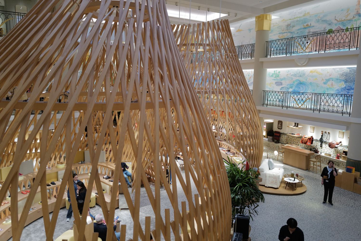 Wooden lattice dome structure in an open atrium space with multiple floors.