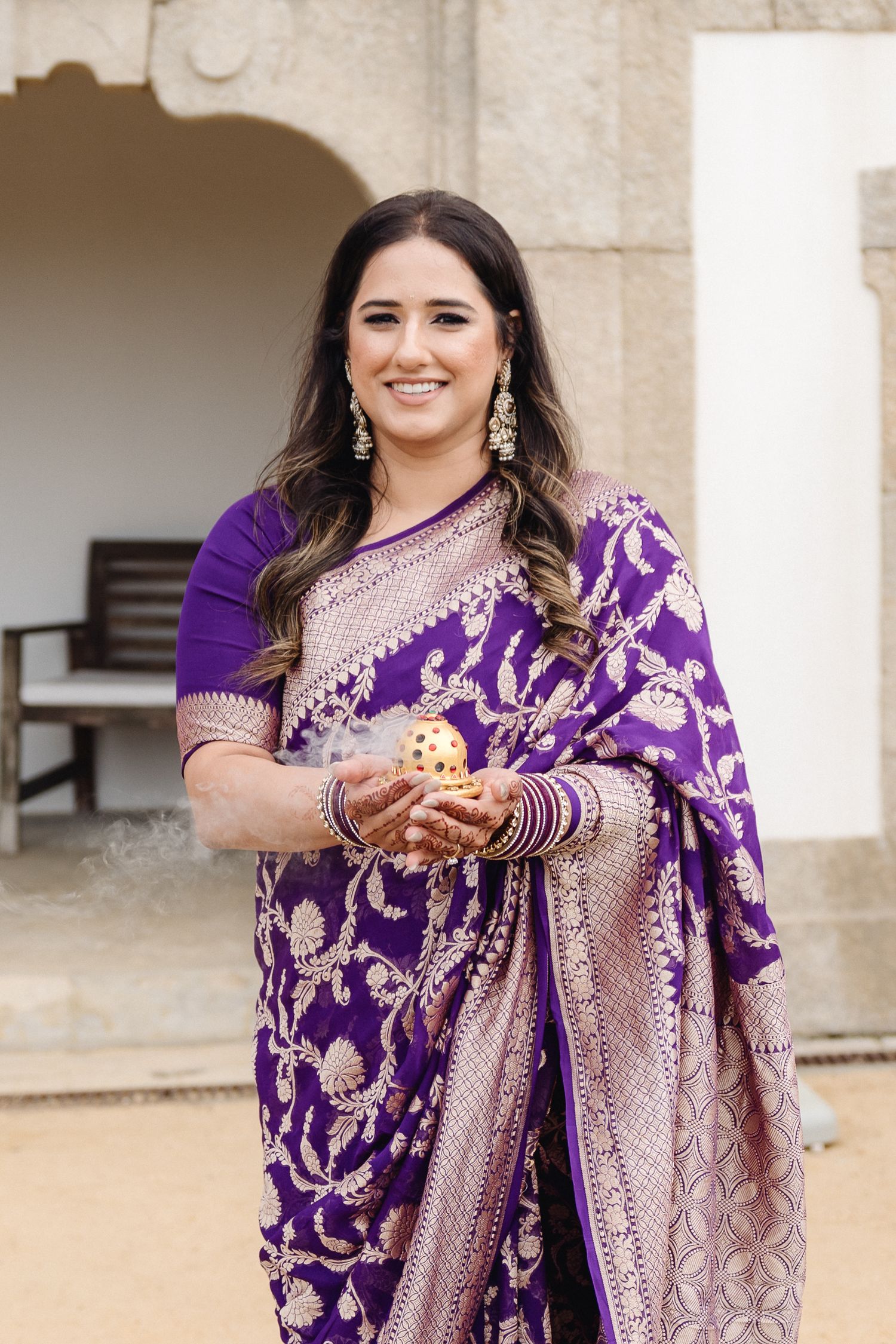 Traditional Indian attire featuring a purple and silver embroidered sari with intricate detailing.
