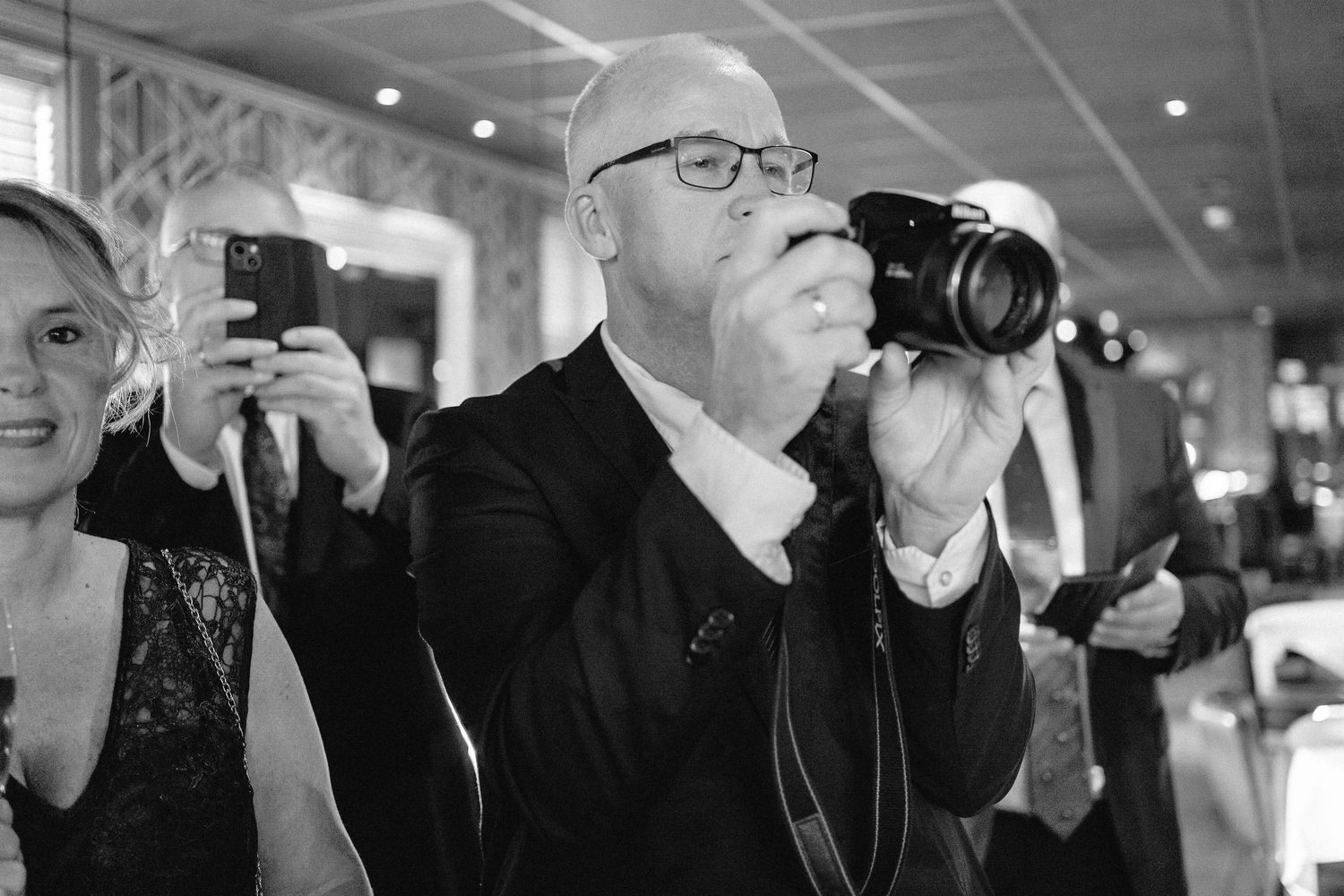 Professional photographers capture moments at a wedding event.