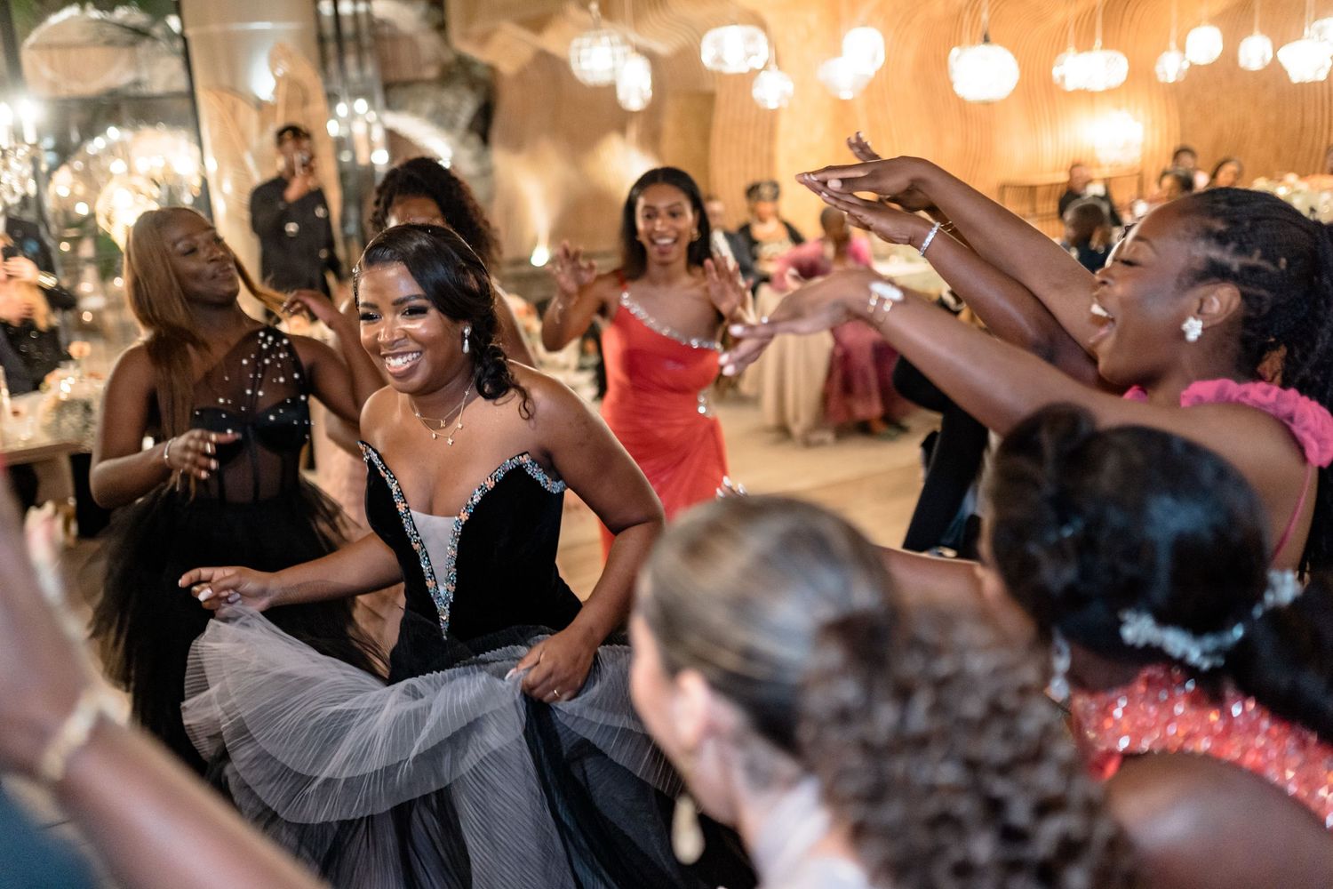 Lively dance floor scene with warm ambient lighting at a wedding reception.