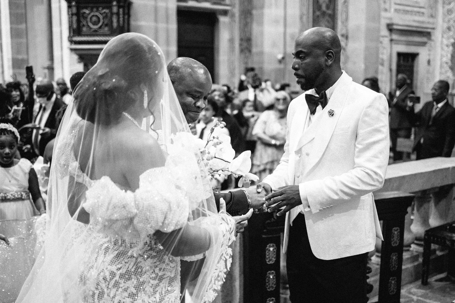 Wedding ceremony moments captured in black and white photography inside a grand church.