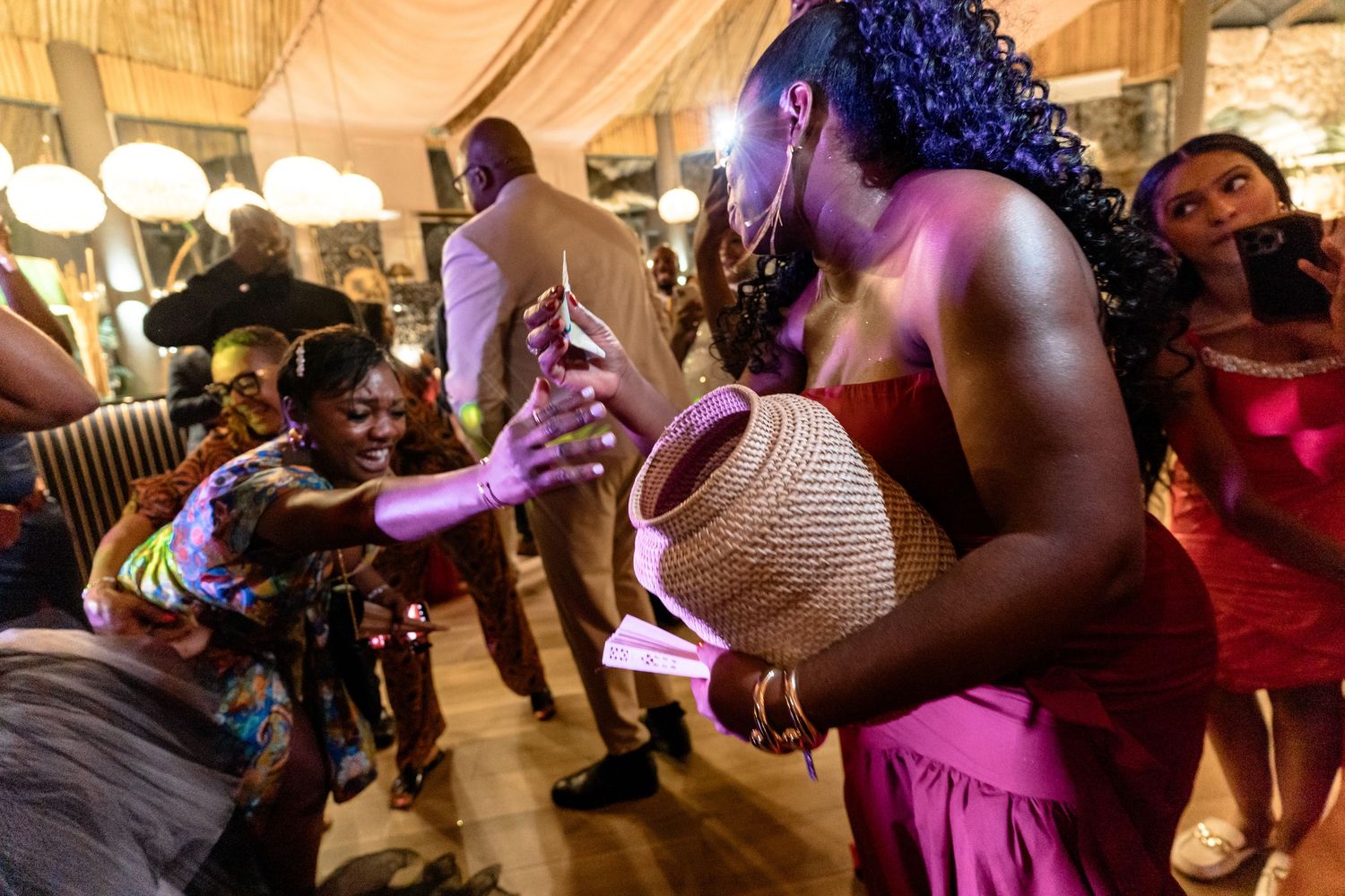 Wedding reception dance floor filled with guests celebrating under warm lighting.