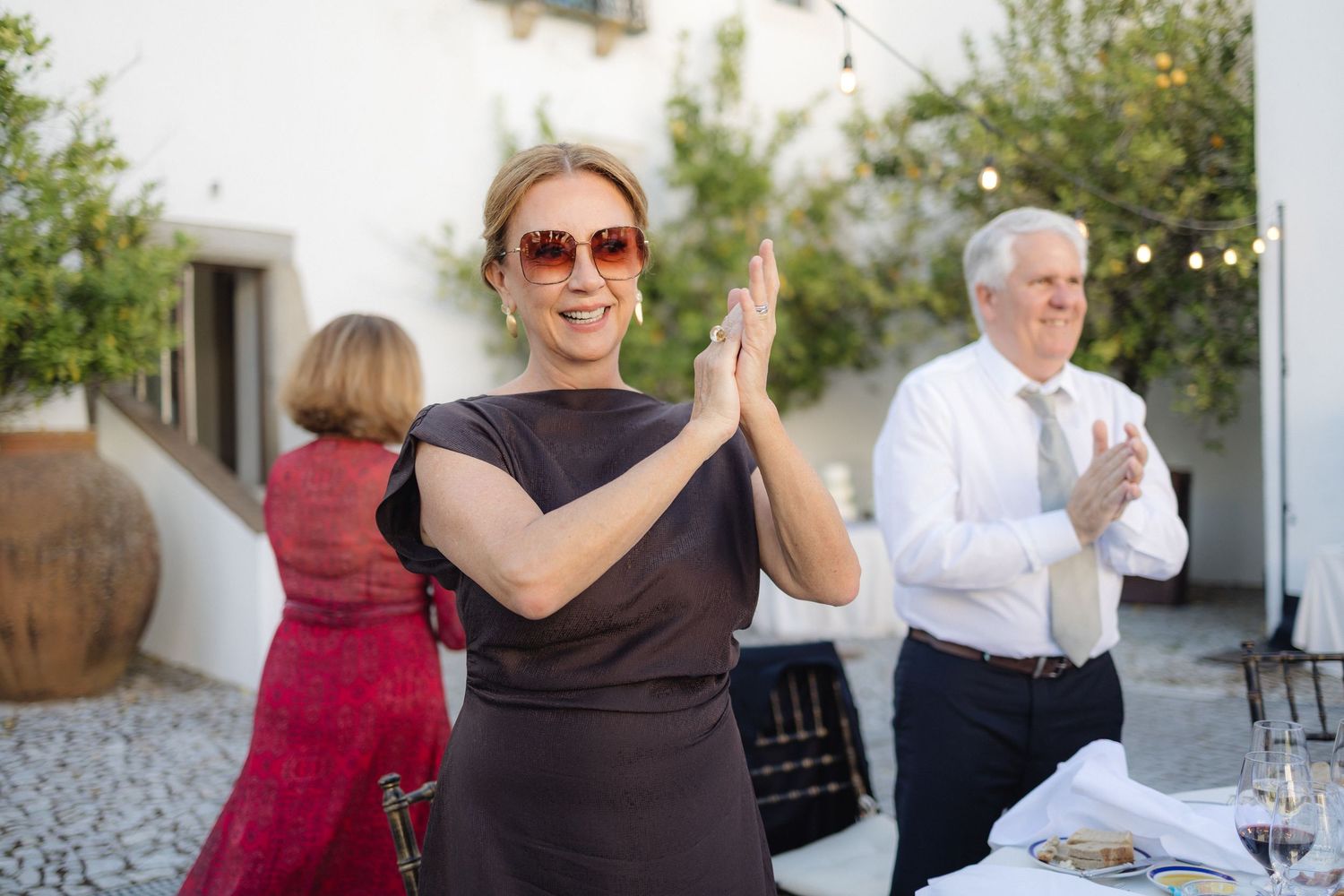 Outdoor wedding reception with guests dancing and socializing.
