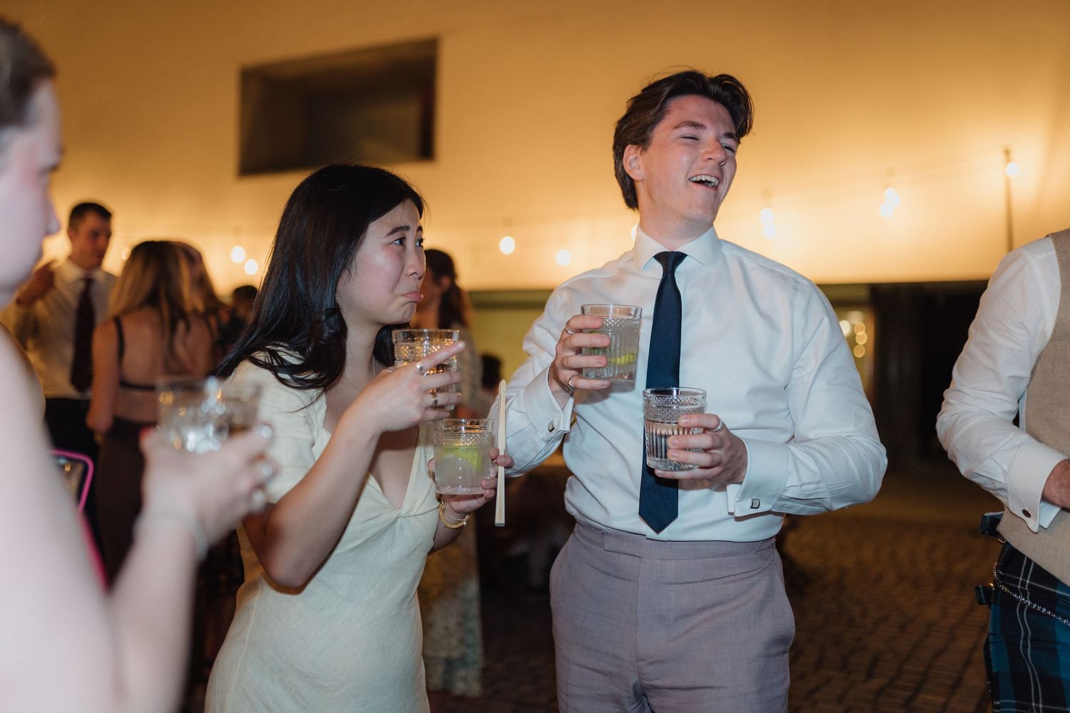 Party guests enjoying drinks and conversation at an evening celebration.