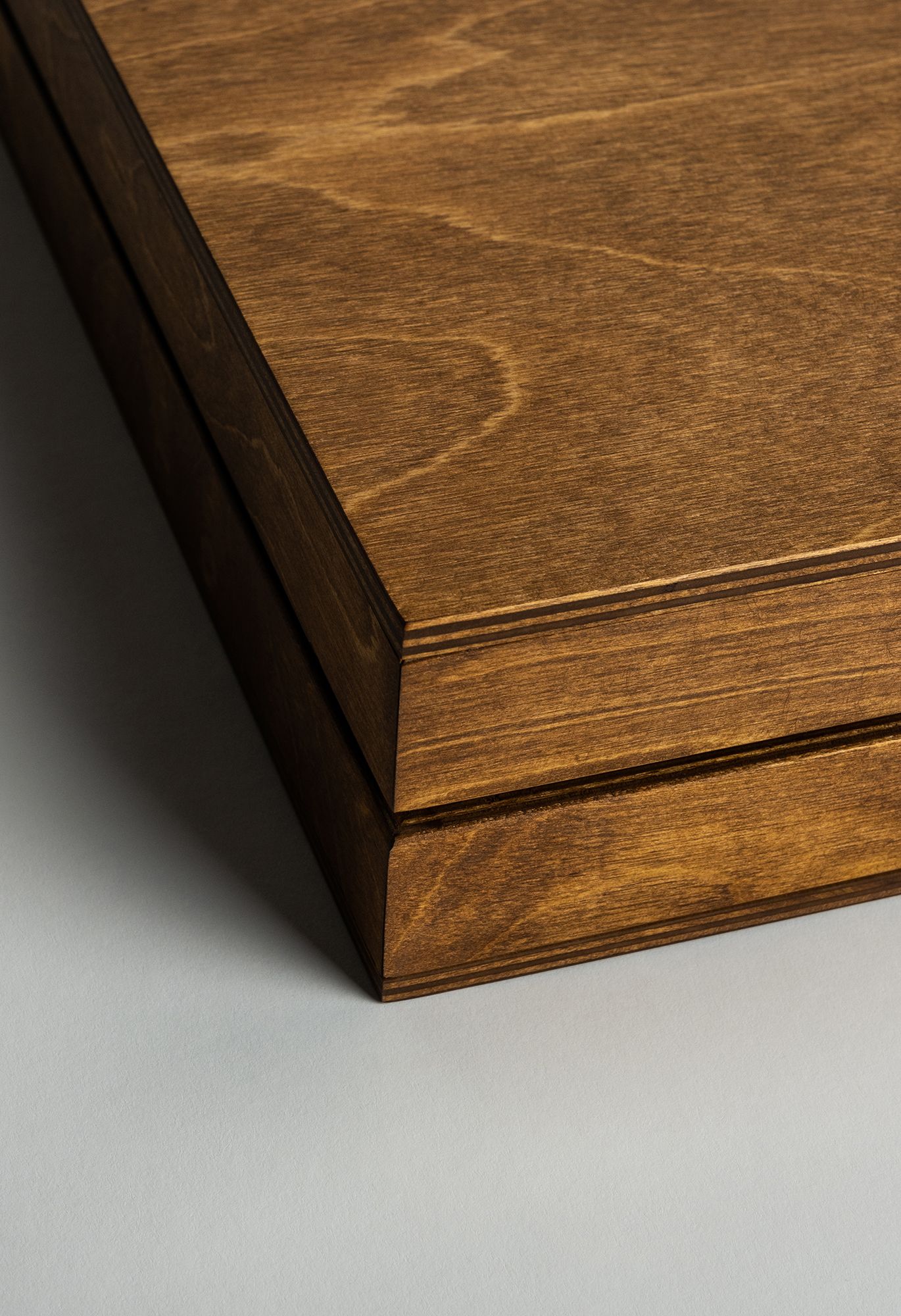 Close-up view of dark stained wood table edge showing beveled detail and smooth finish texture.