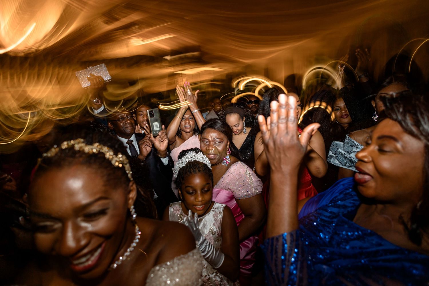 Energetic crowd celebrating on a dance floor with dynamic lighting effects.