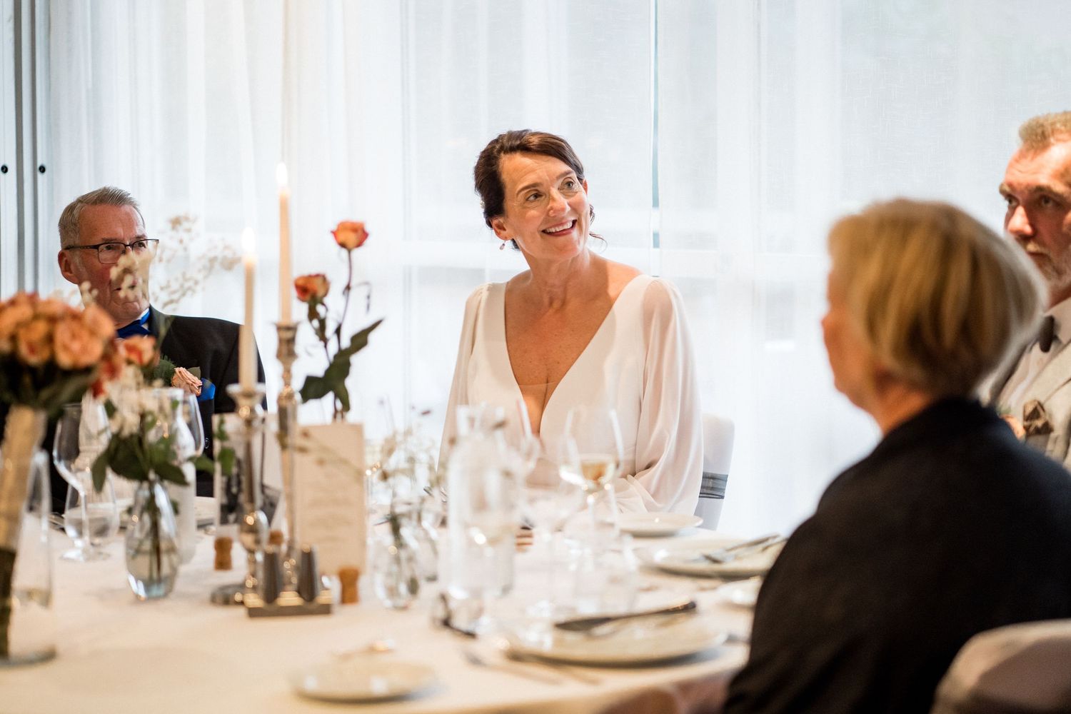 Wedding reception table settings with elegant glassware and decorative centerpieces.