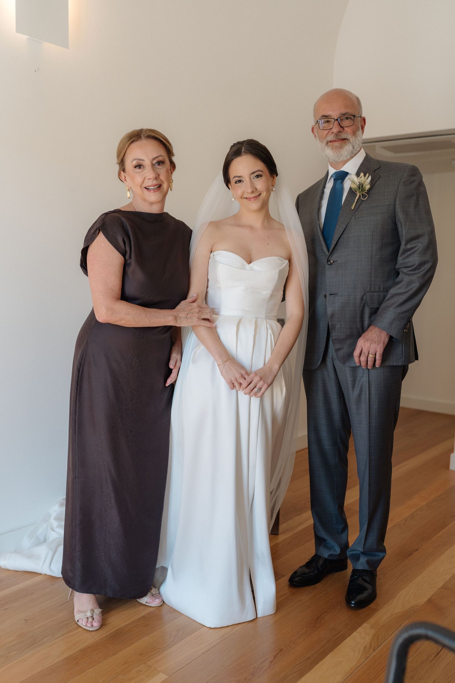 Formal wedding portrait showing bride in white gown with two companions.