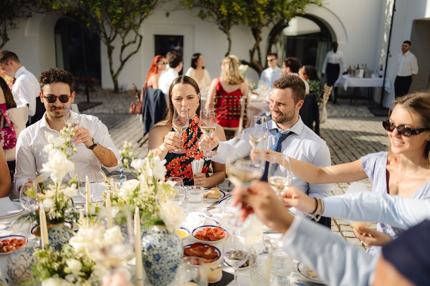 Elegant outdoor wedding reception with white floral centerpieces and place settings.