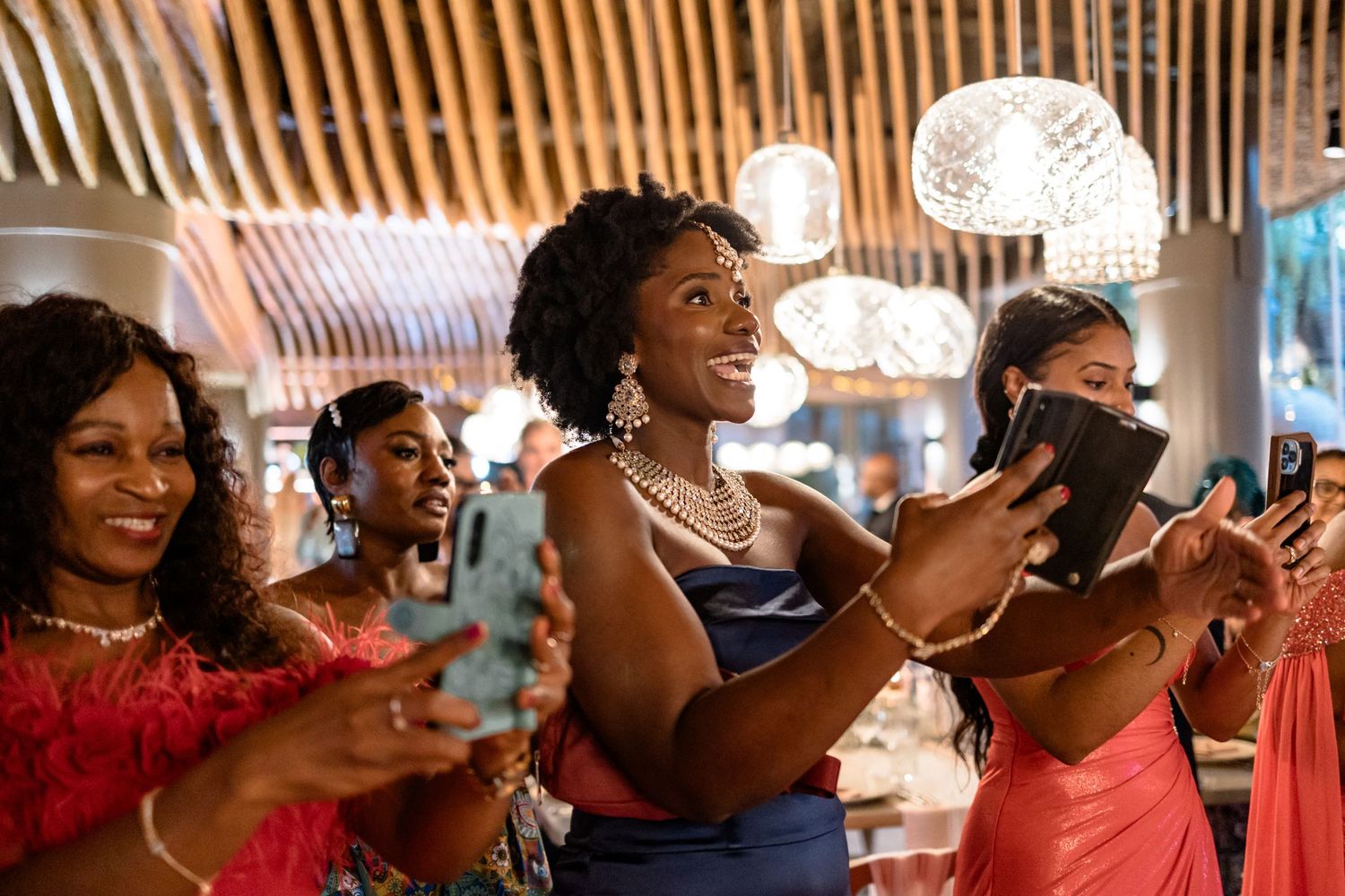 Wedding reception guests celebrating and clapping during an evening celebration.