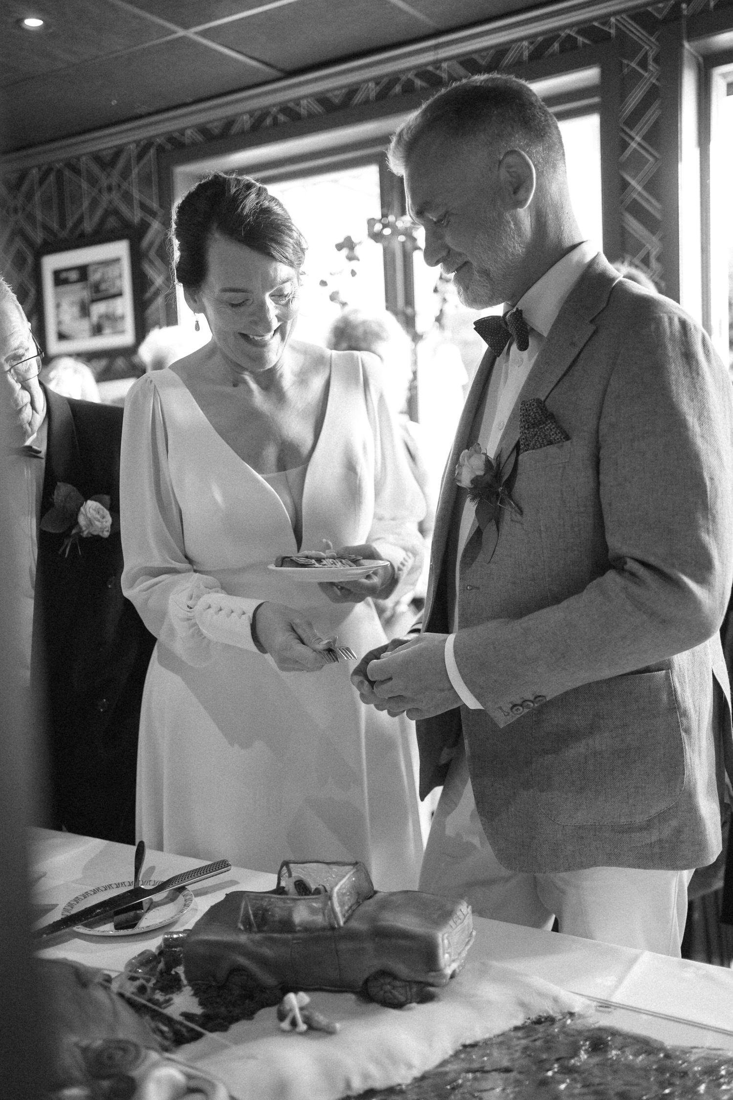 Black and white photos of newlyweds signing marriage documents during their wedding ceremony.