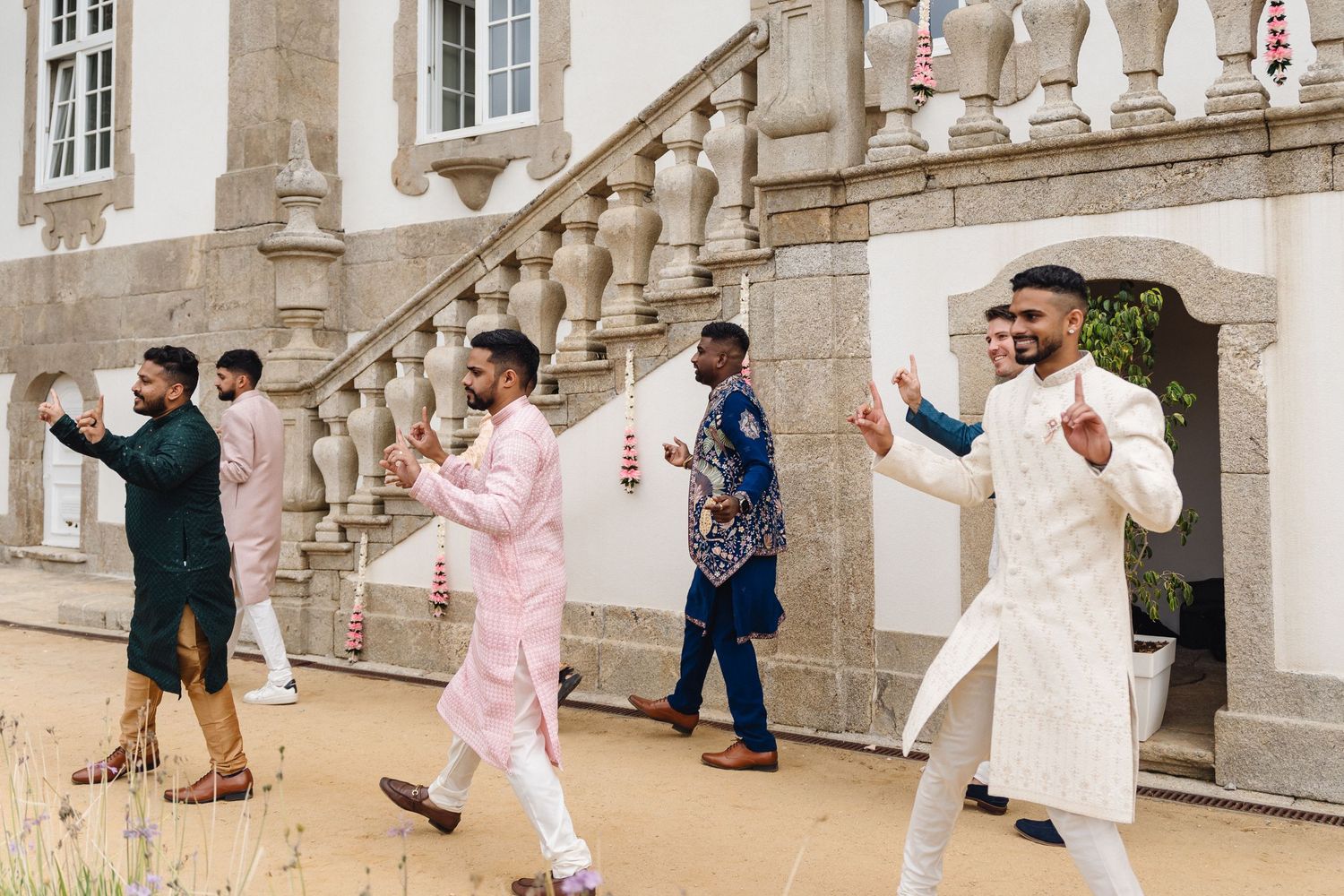 Wedding guests celebrating and dancing on a stone terrace.