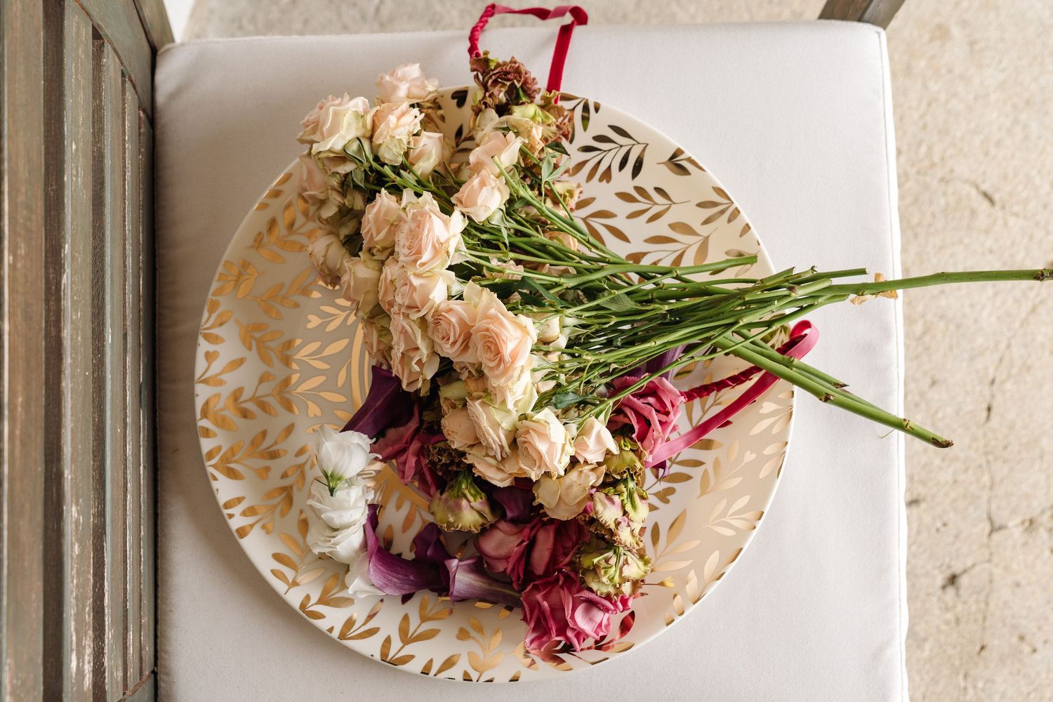 Elegant floral arrangements with pink and white roses displayed on cream-colored plates.