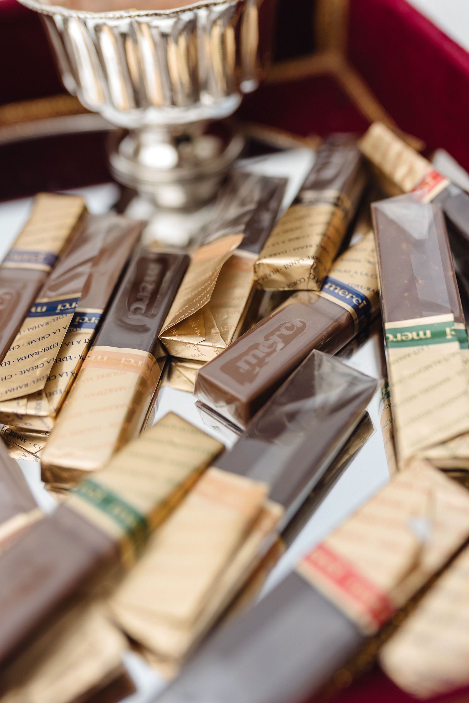 Assorted chocolate bars and candy wrappers arranged on a dark surface.