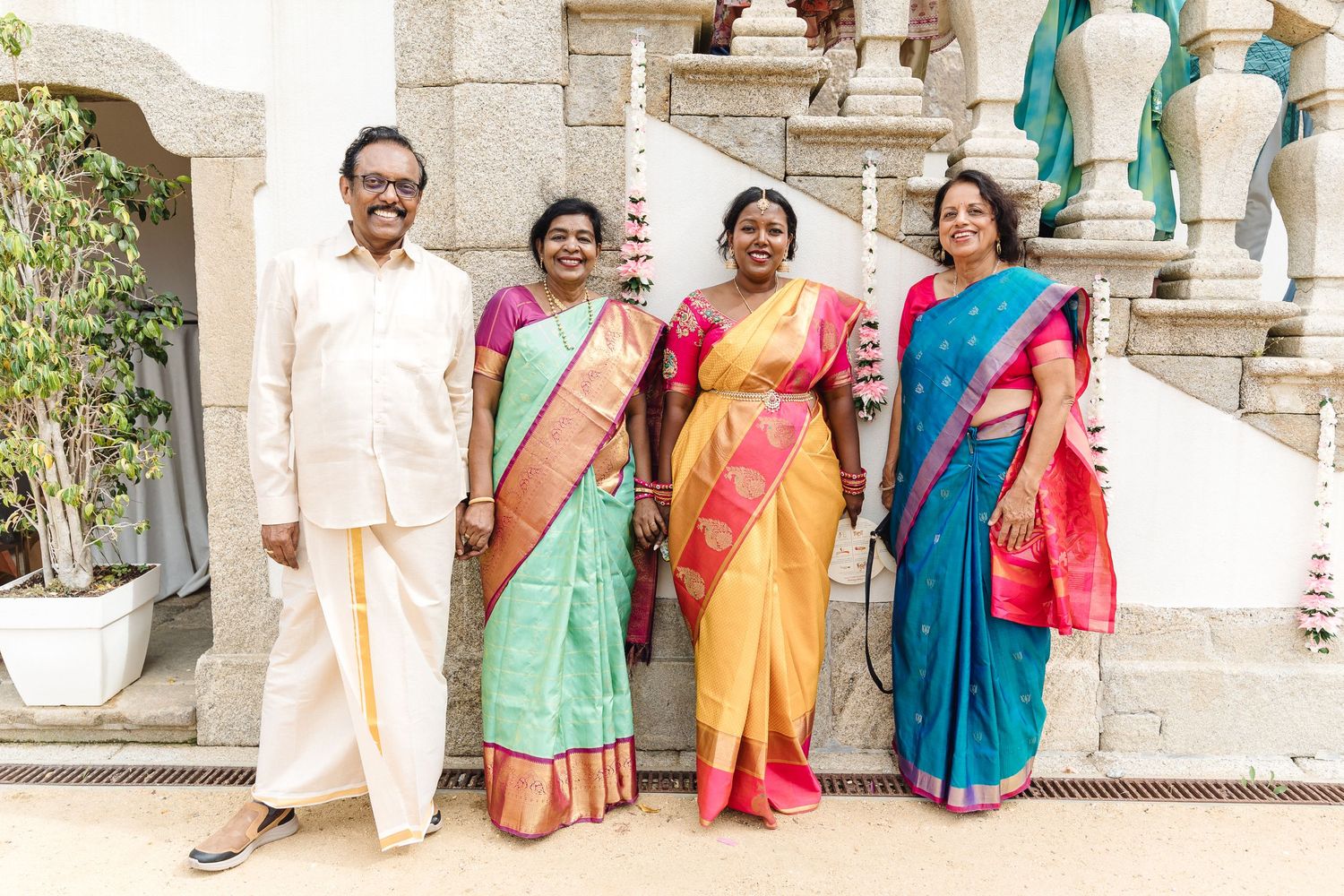 Colorful group photo featuring traditional Indian saris and formal attire at a cultural celebration.
