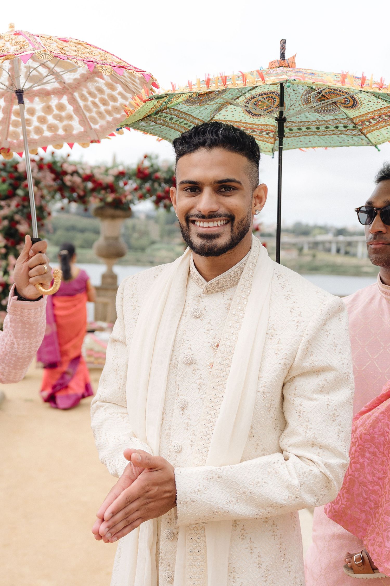 Wedding guests holding decorative parasols during an outdoor celebration.