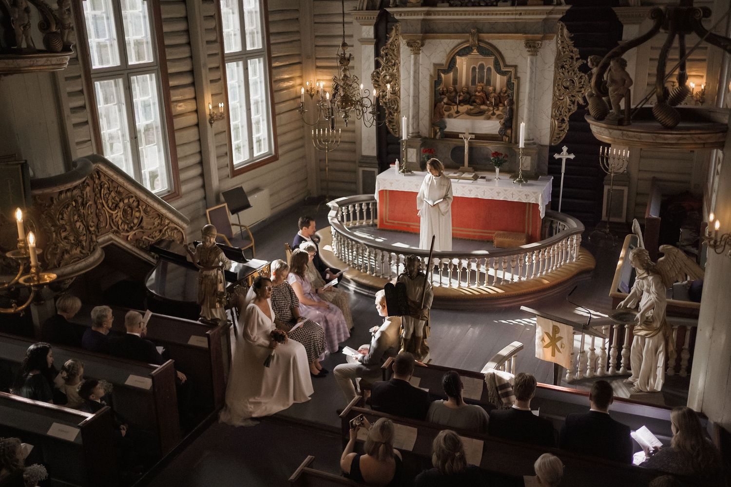 Historic church interior with wooden pews and ornate architectural details lit by natural light.