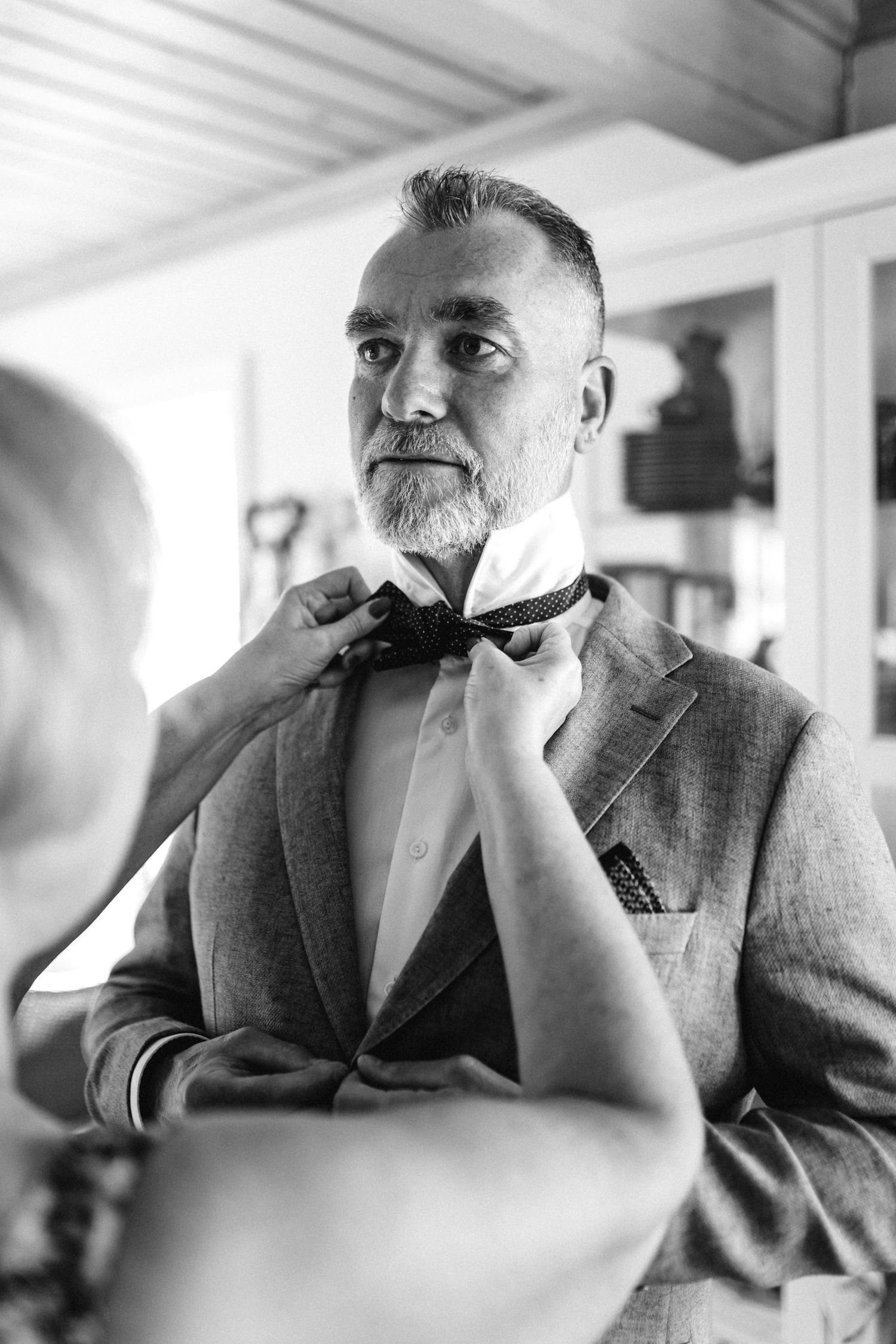 Black and white portrait of a distinguished gentleman in a suit smoking a pipe in contemplative poses.