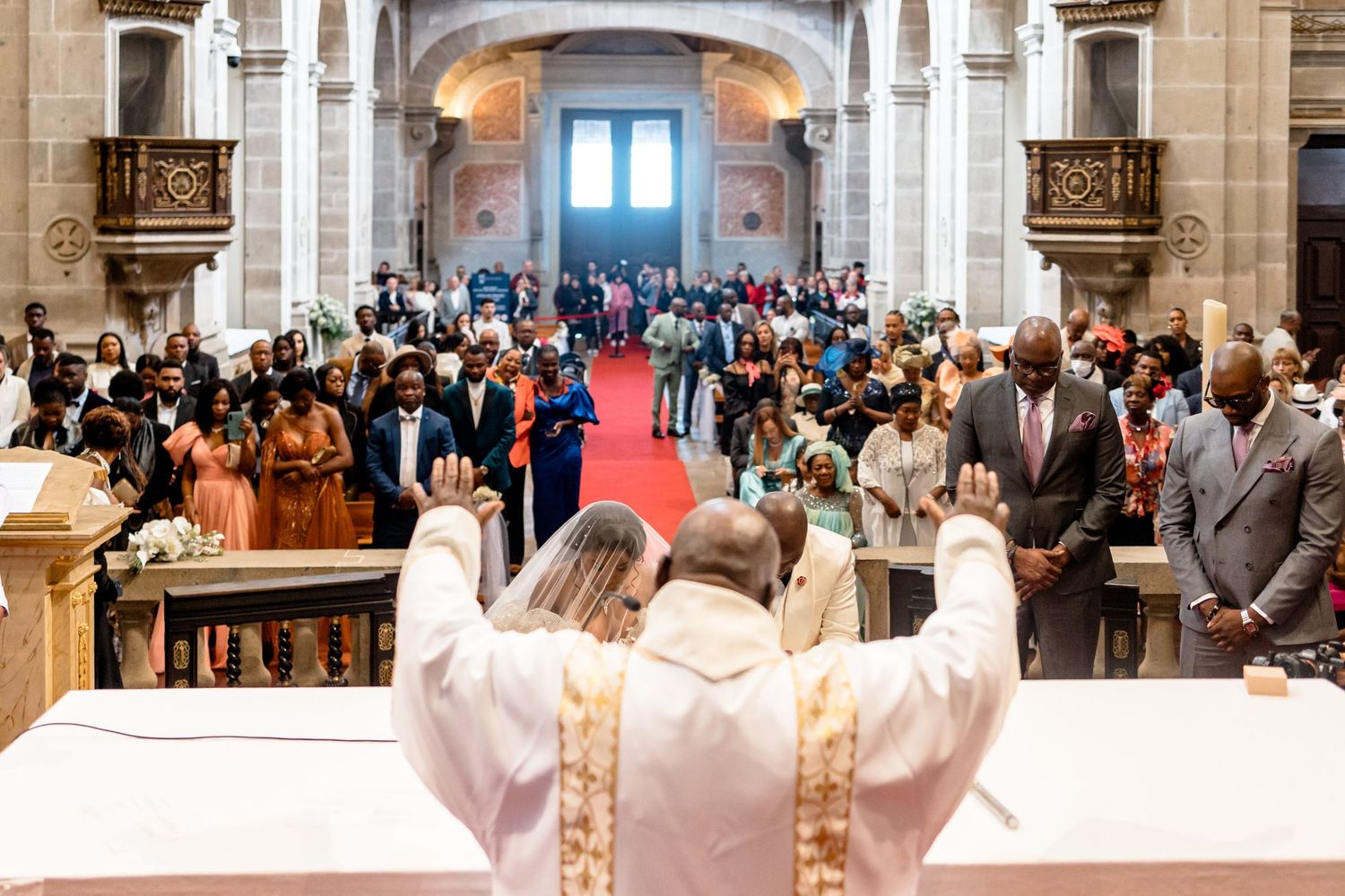 Religious ceremony in progress within a grand cathedral with high vaulted ceilings.