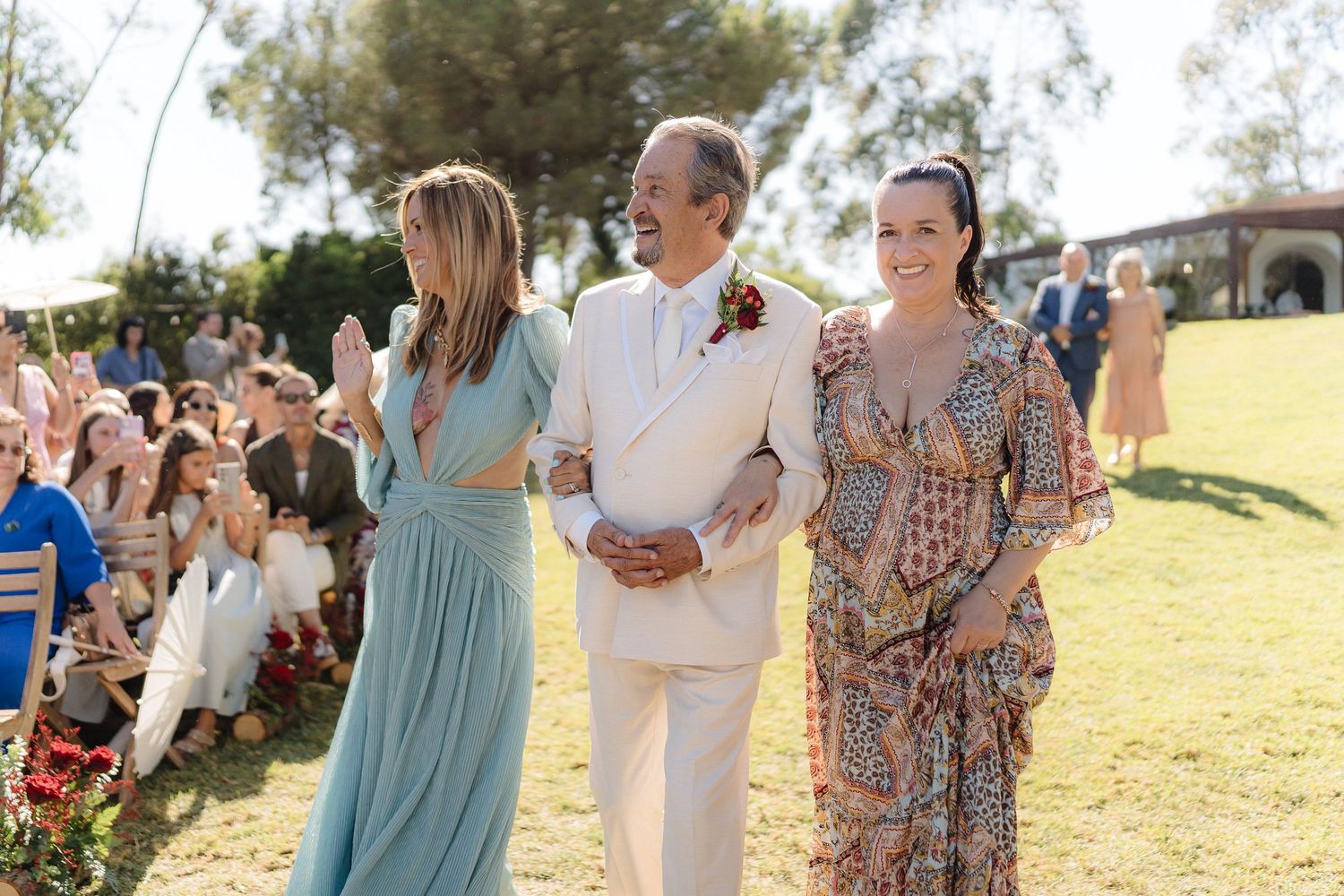 Candid moments captured between wedding guests during an outdoor celebration.