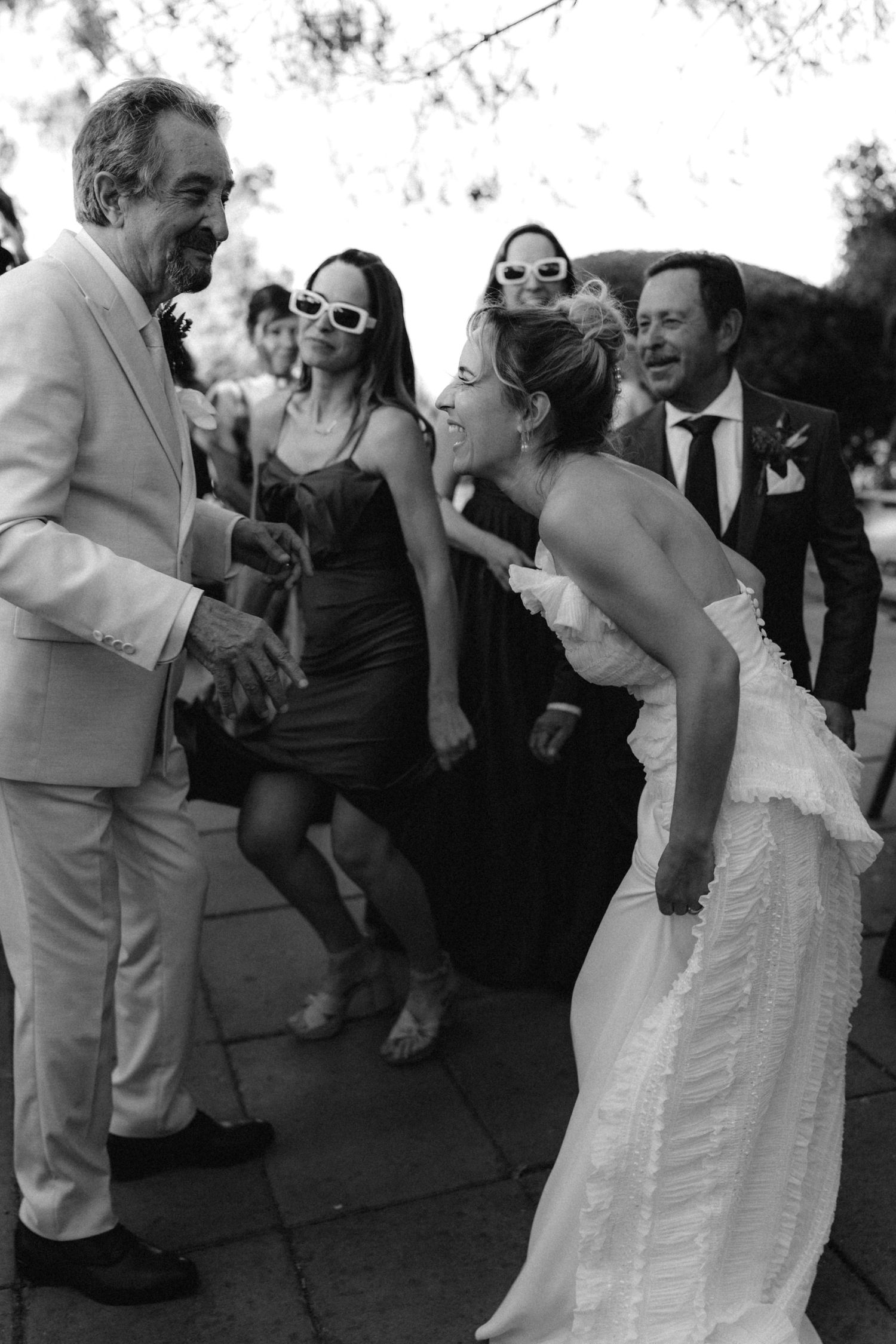 Black and white photo of wedding guests dancing and celebrating.