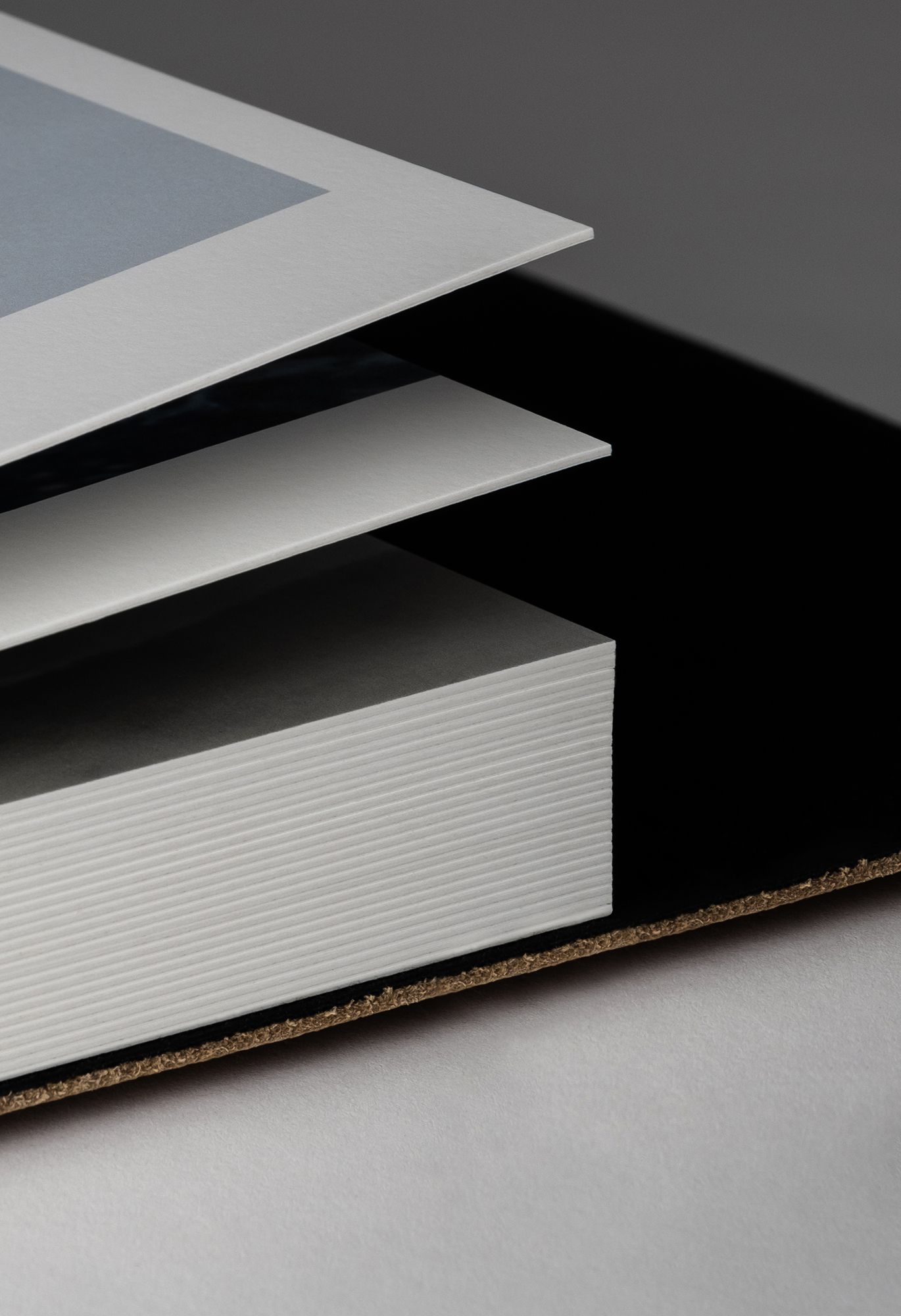 Close-up view of white laminate material layers with particle board core shown in cross-section against gray background.