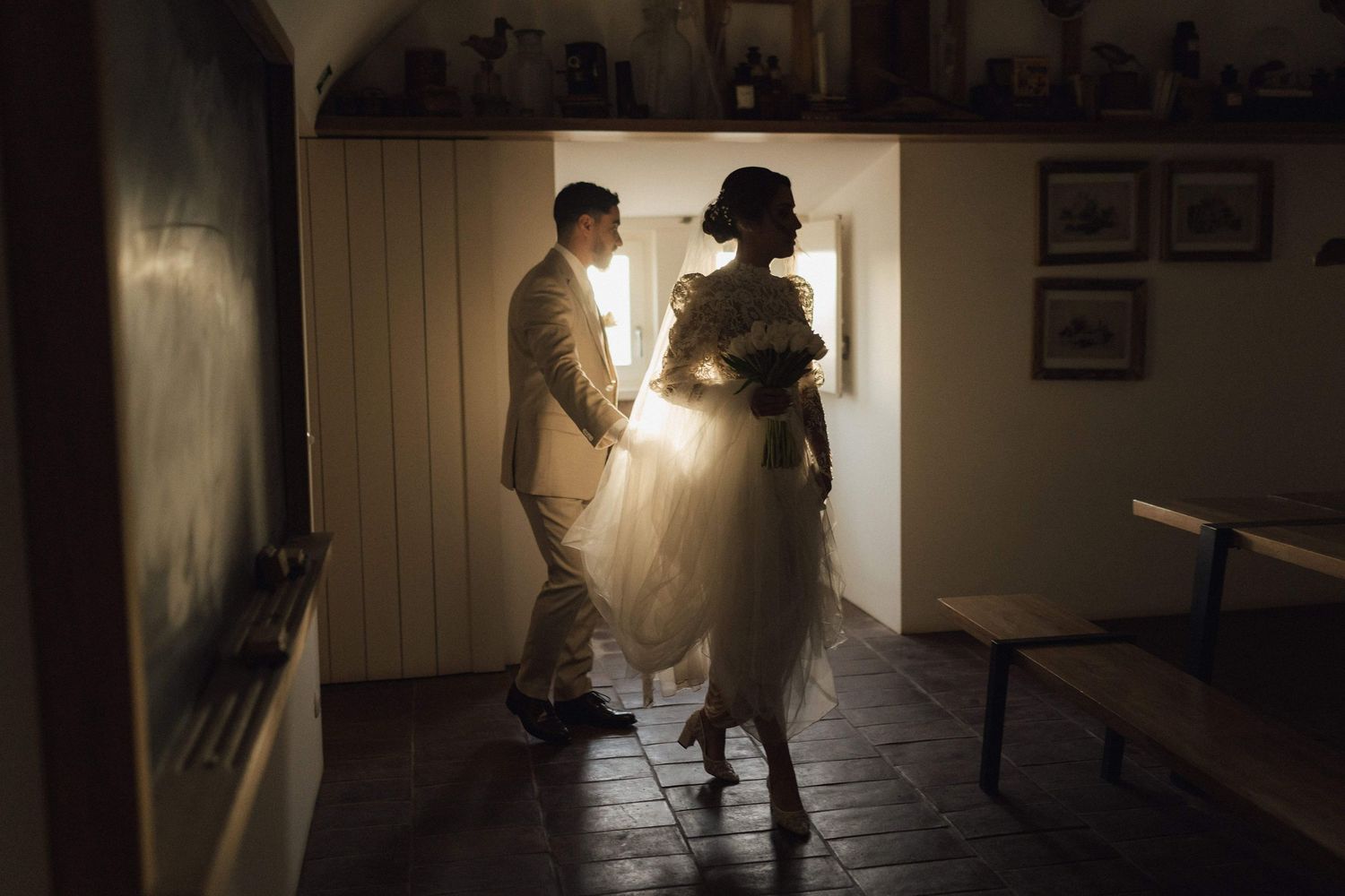 Silhouetted wedding couple in a dimly lit hallway creating a romantic atmosphere.
