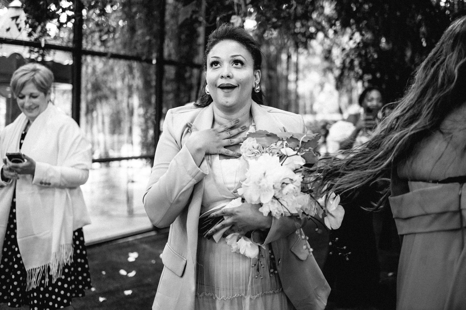 Black and white candid shots of wedding guests reacting with joy during the celebration.
