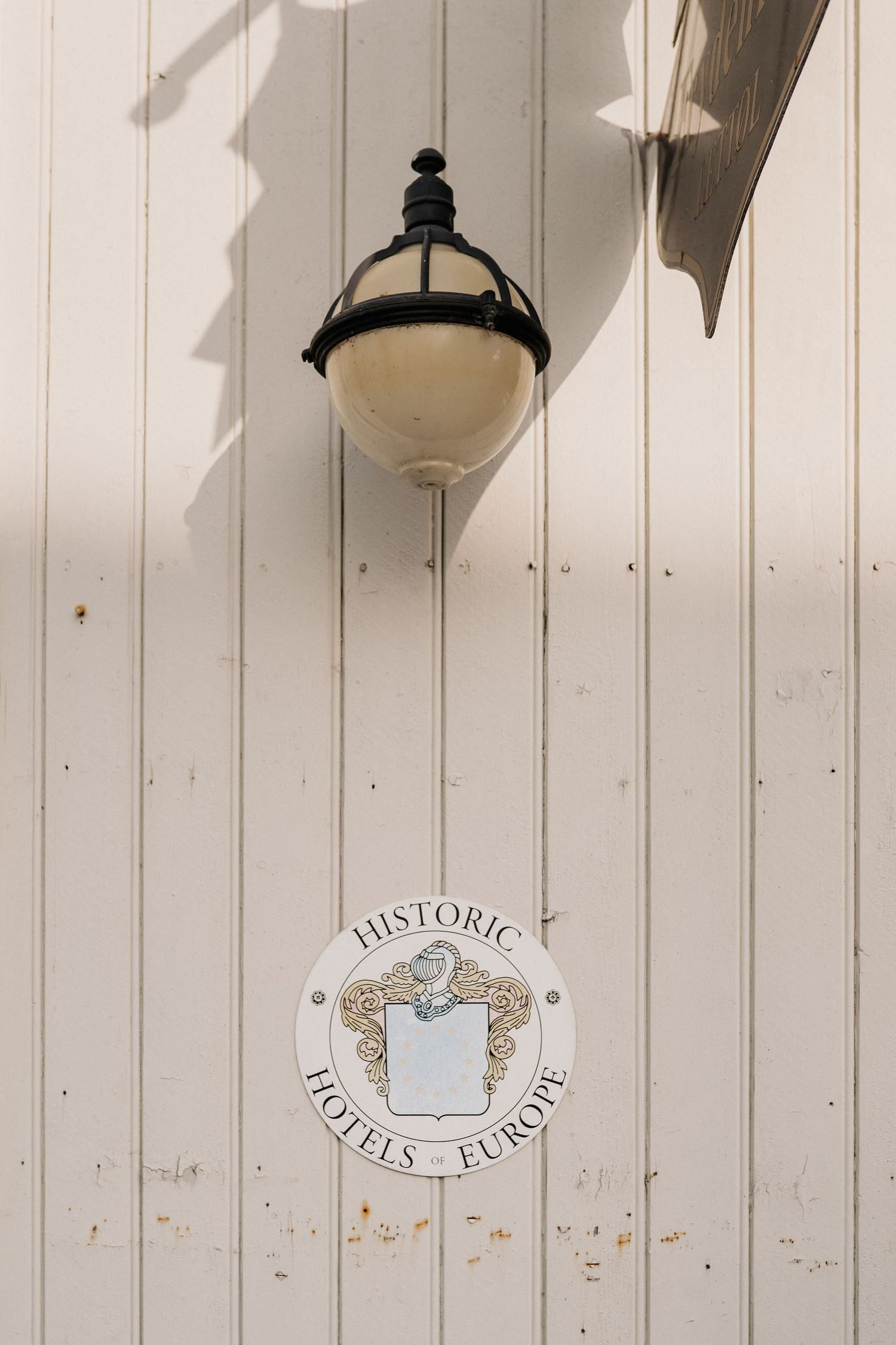 White wooden wall with vintage decorative elements and lighting fixtures.