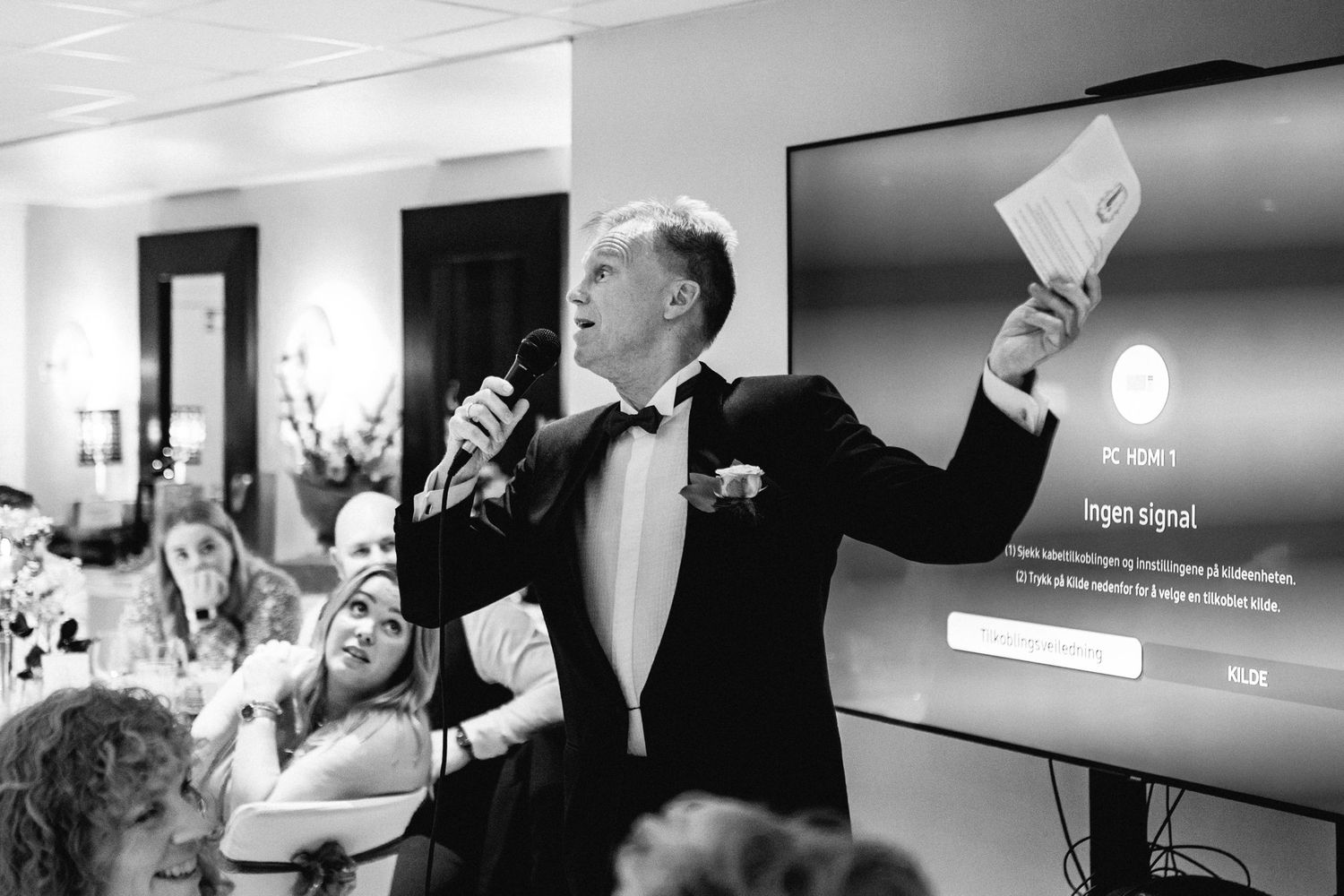 Black and white images showing guests enjoying speeches and celebrations at a wedding reception.