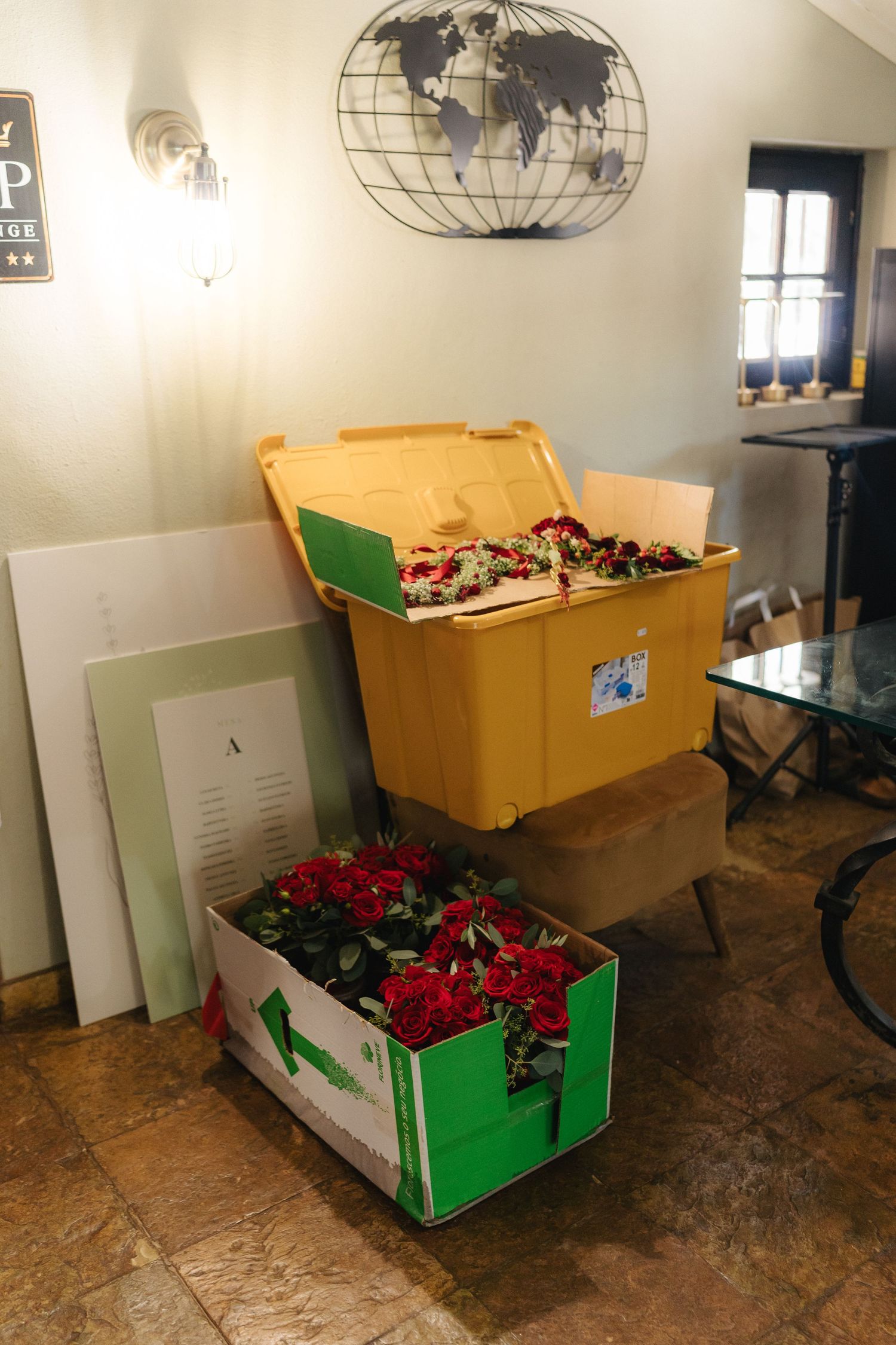 Storage room with world map decor and boxes filled with red flowers.