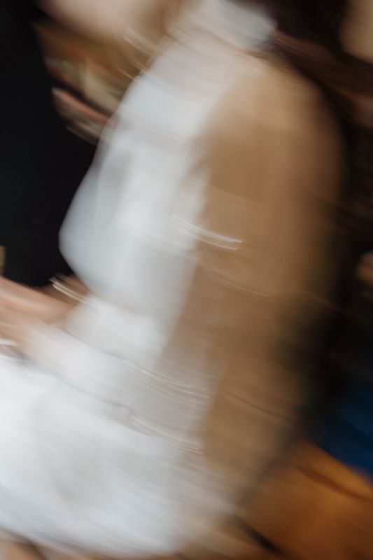 Abstract motion blur of white wedding dress creates an artistic effect.