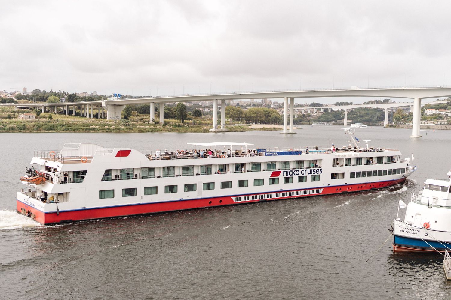 Row of large river cruise ships docked along a waterfront.