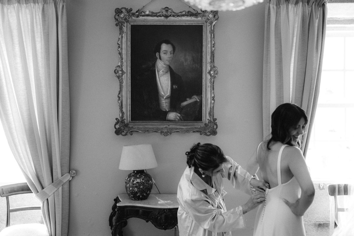 Panoramic view of bridal preparations in a formal room with ornate frames and curtains.