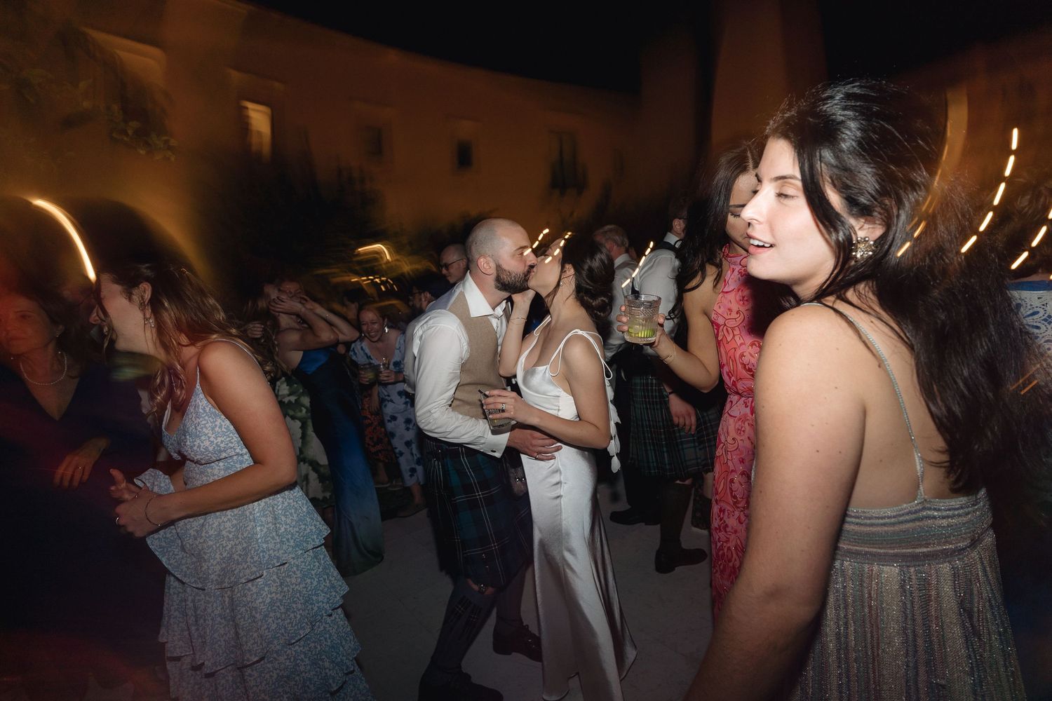 Guests dancing and enjoying themselves at an evening wedding reception.