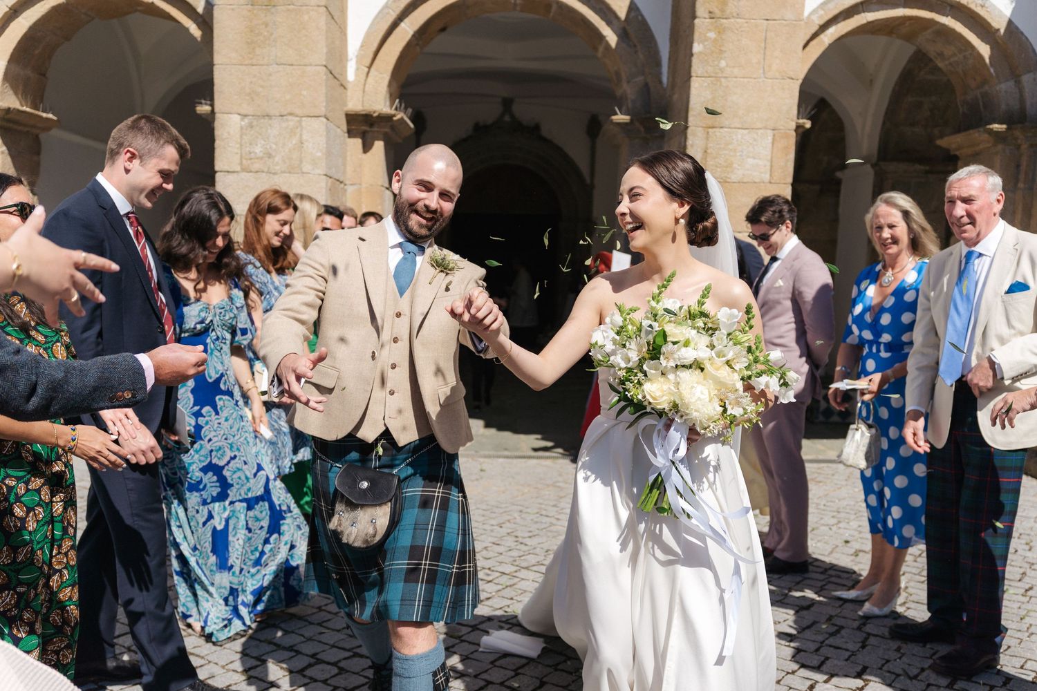 Guests celebrate at an outdoor wedding reception with joyful expressions.