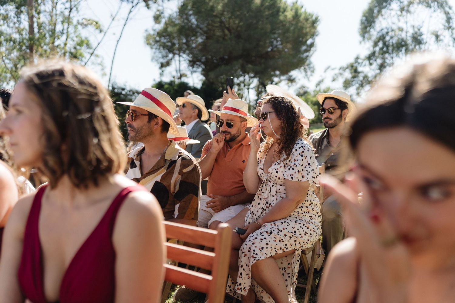 Wedding guests enjoying emotional moment during outdoor ceremony.