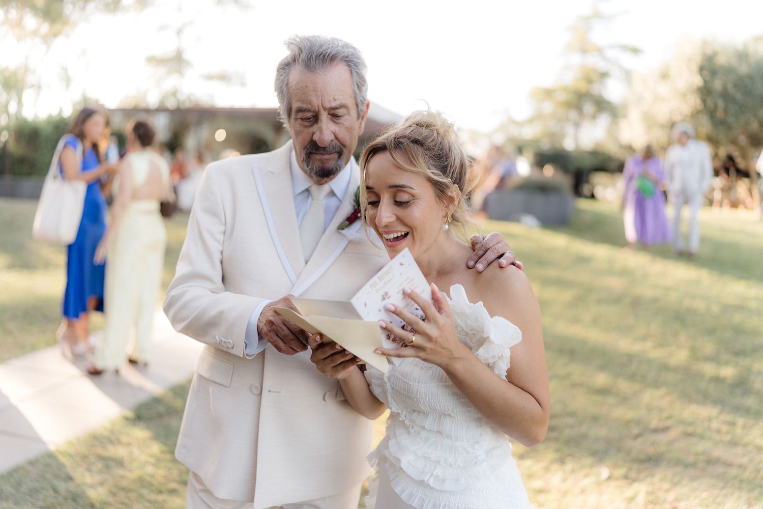 Emotional moment at outdoor wedding as couple looks at something together.