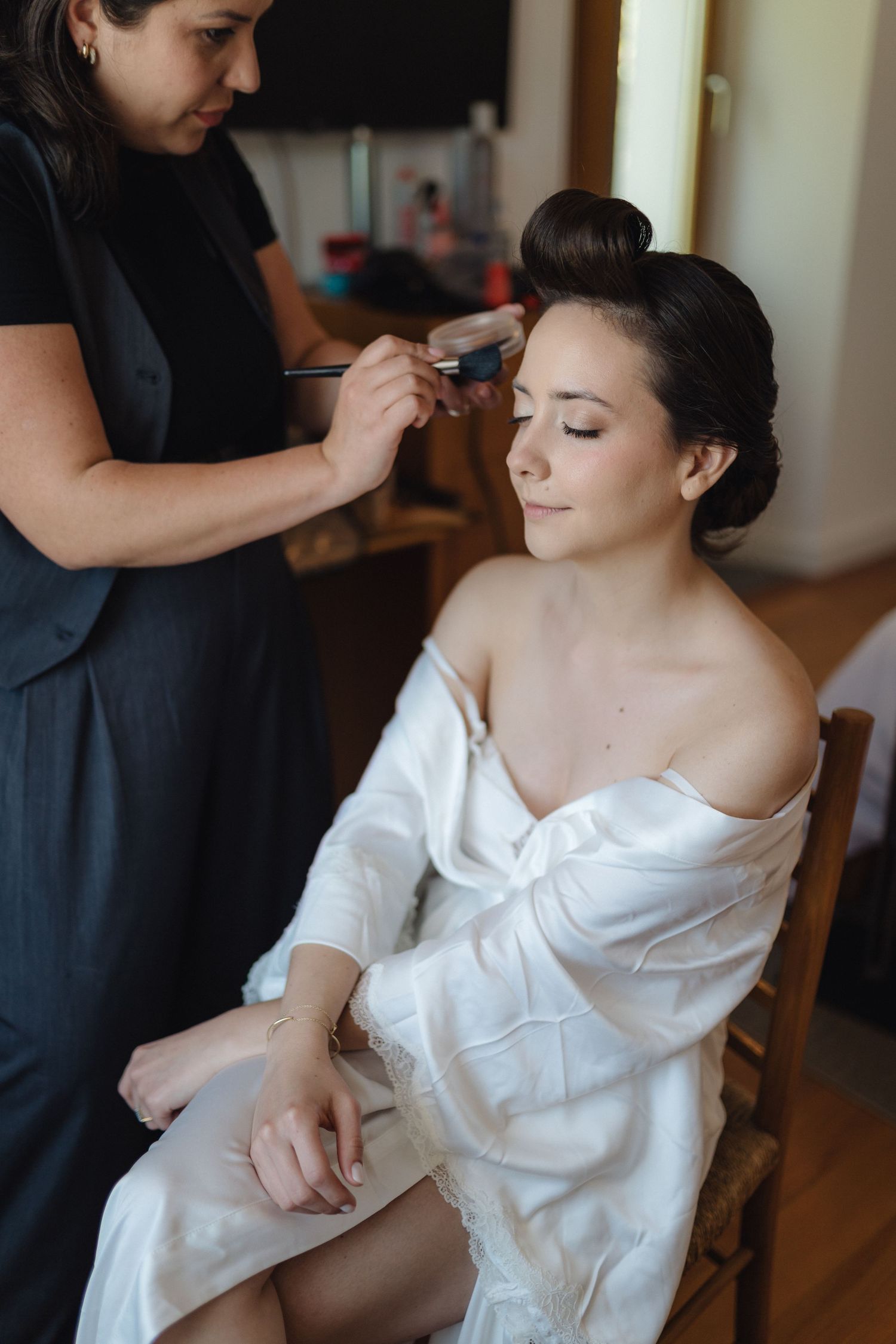 Makeup application session during wedding preparations.